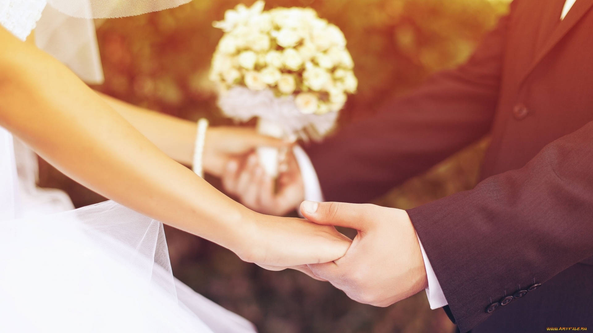 Wedding 桌布 壁紙 — 新娘和新郎在柔和的金色陽光下手持白色花束牽手。