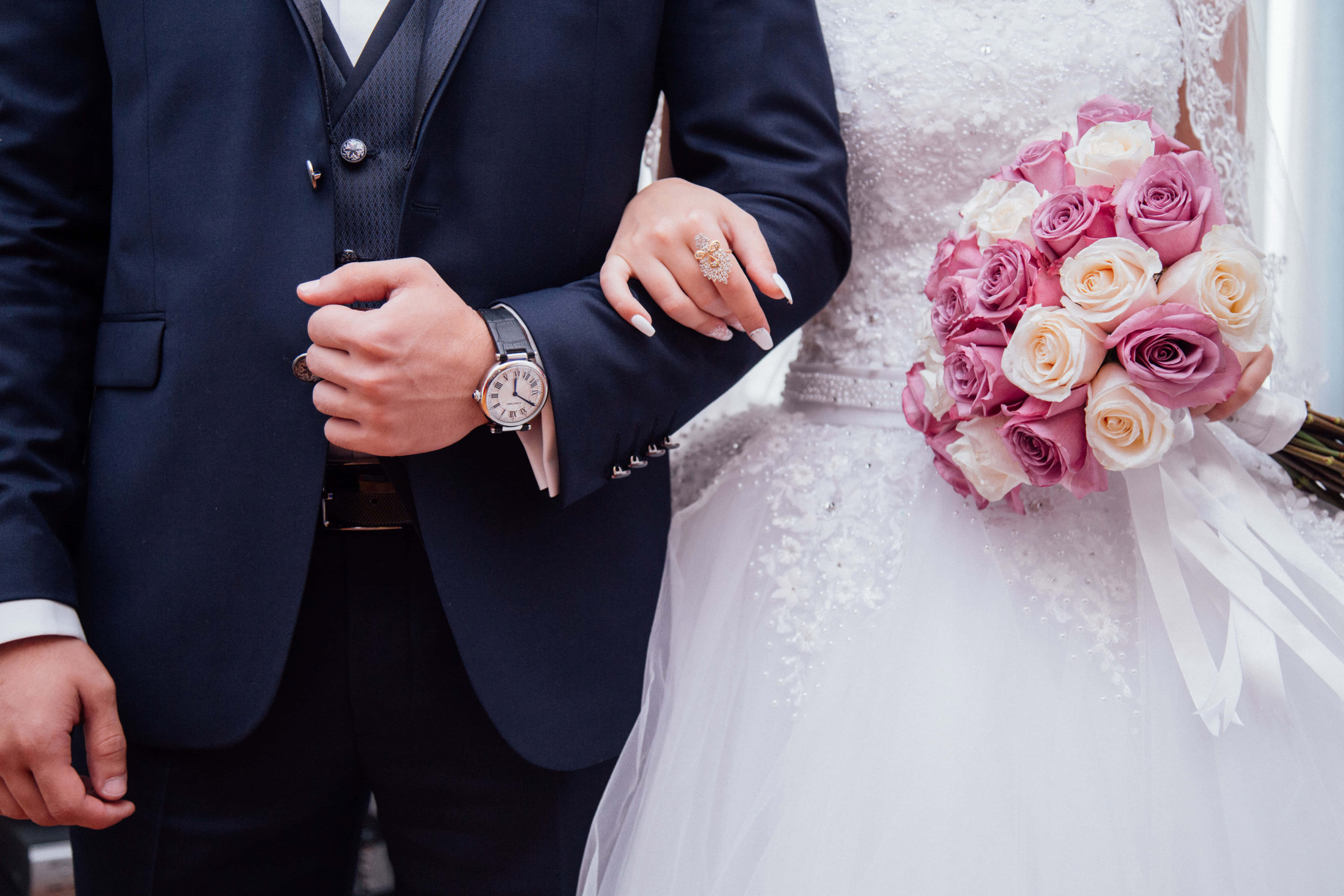 Wedding 桌布 壁紙 — 新娘和新郎牽手的特寫，新娘手持粉白色玫瑰花束。