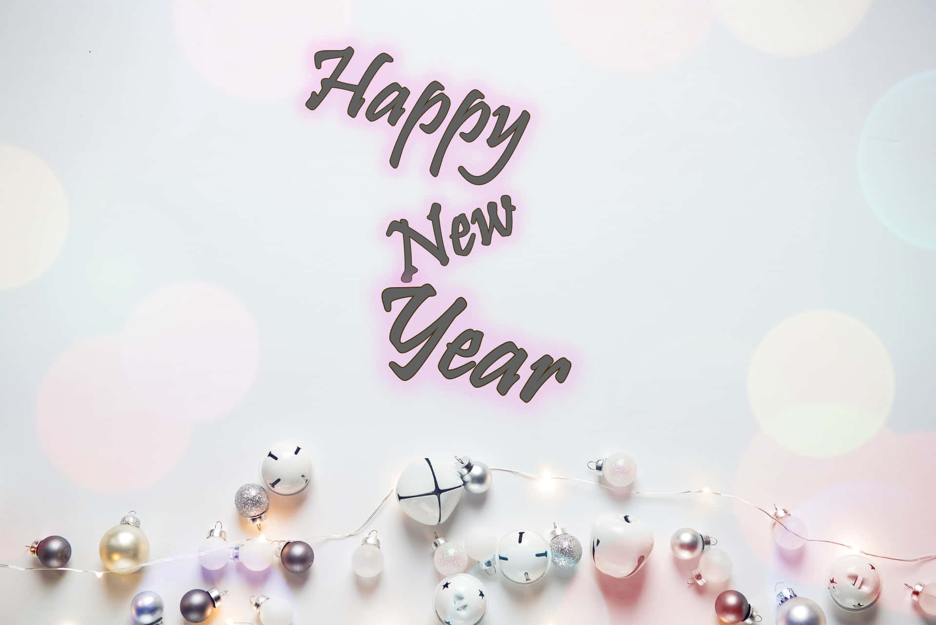 新年 桌布 壁紙 — 新年快樂文字在柔和散景背景上，在一串節日裝飾品和閃爍燈光上方微微發光。