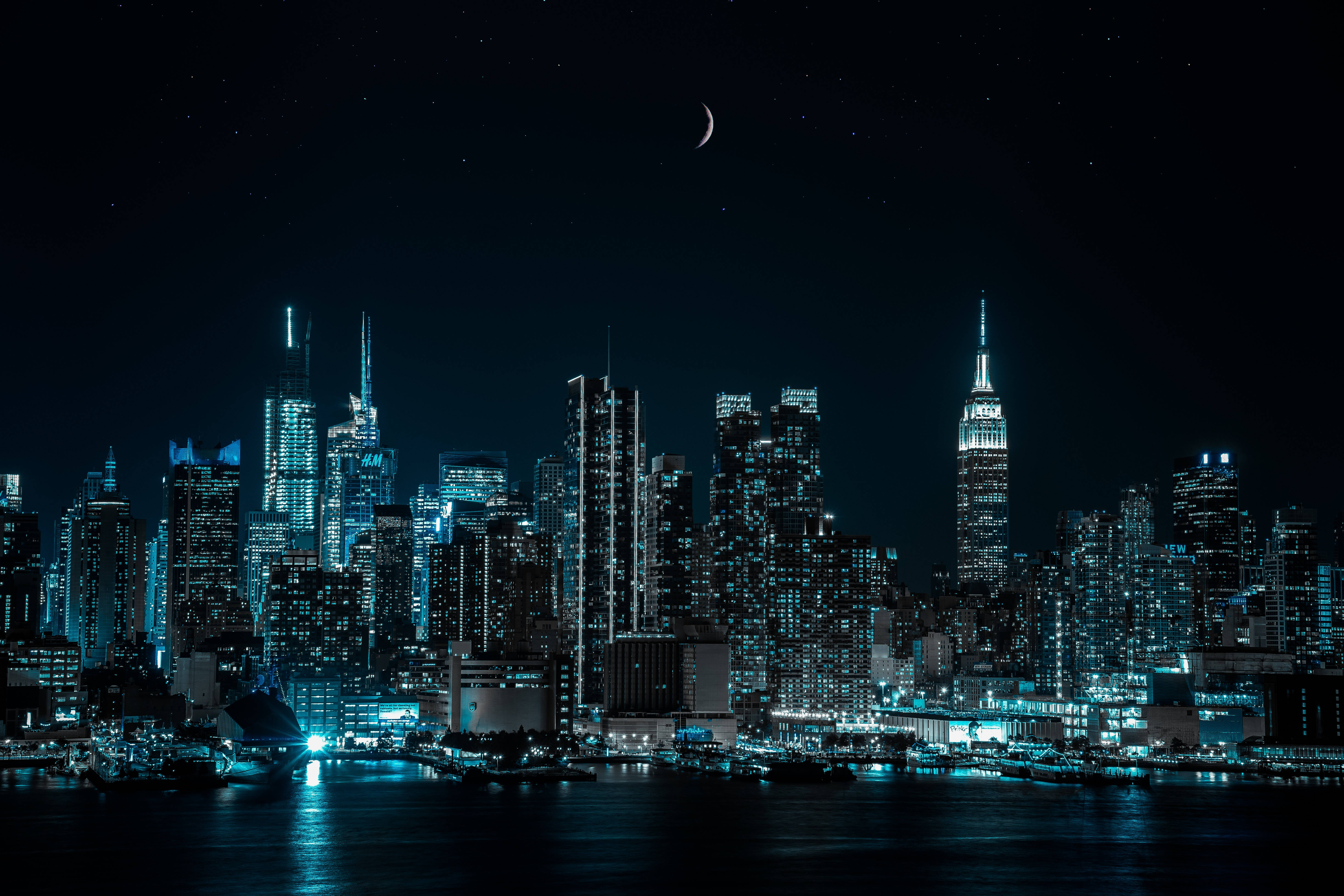 New York Skyline 桌布 壁紙 — 新月下，璀璨城市天際線倒映在水中的迷人夜景。