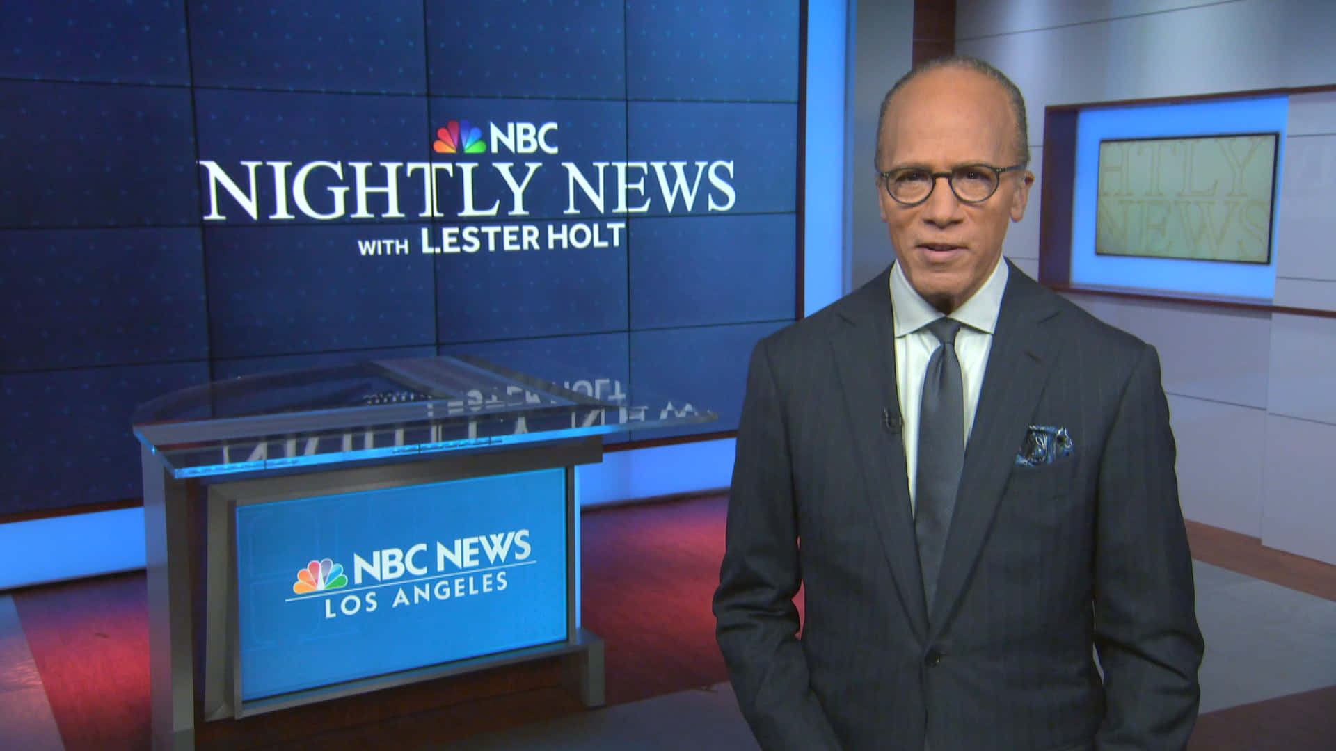 Anchor 桌布 壁紙 — 新聞主播萊斯特·霍爾特站在現代化的NBC Nightly News攝影棚中，配有藍色燈光和時尚的玻璃桌。