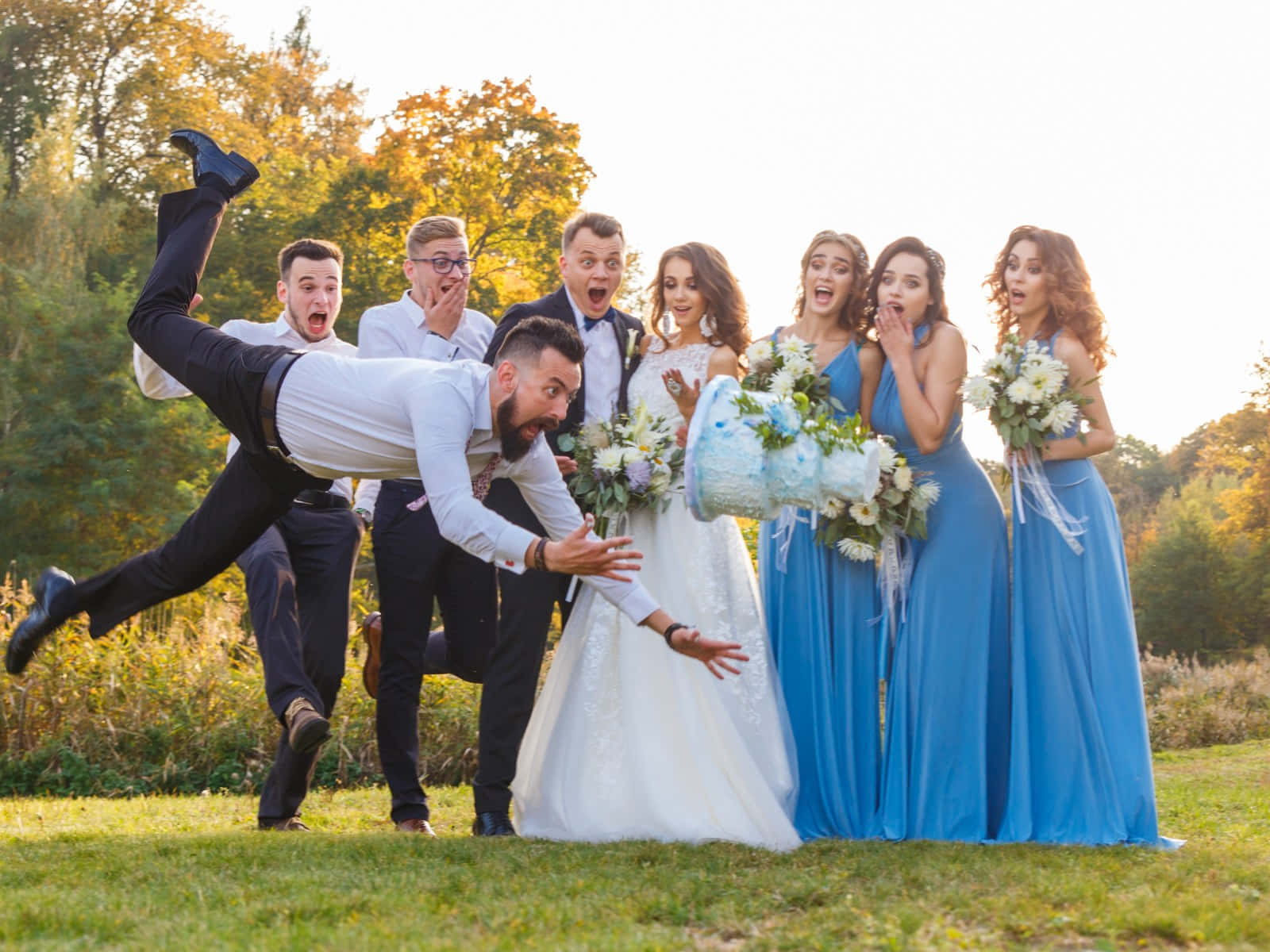Bride And Groom 桌布 壁紙 — 新郎在空中戲劇性地翻轉，婚禮賓客在黃金時段的戶外慶祝活動中震驚地倒吸一口氣。