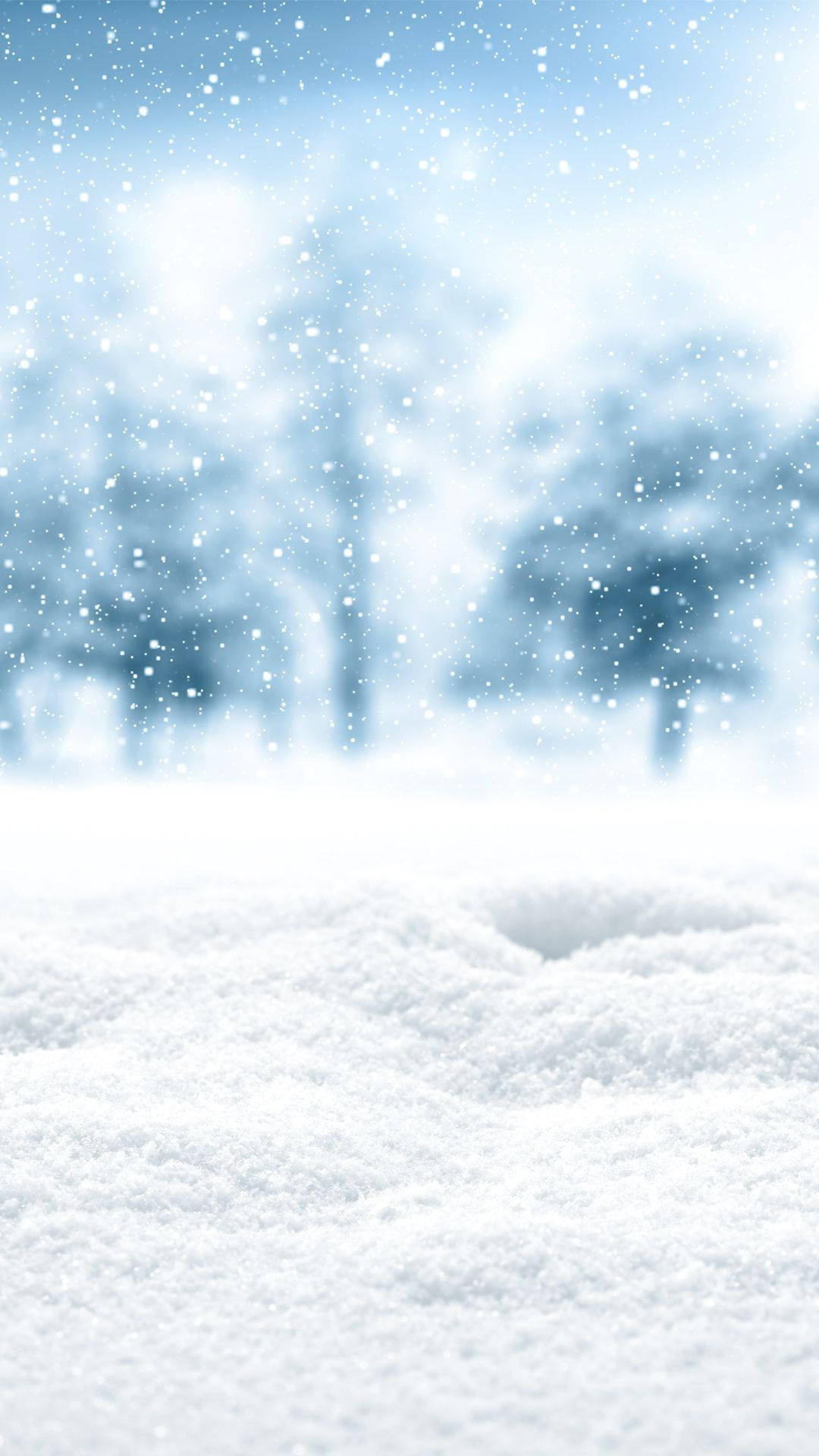 雪 桌布 壁紙 — 新雪覆蓋地面，溫柔的雪花在柔和的藍色冬日天空中飄過模糊的樹木。