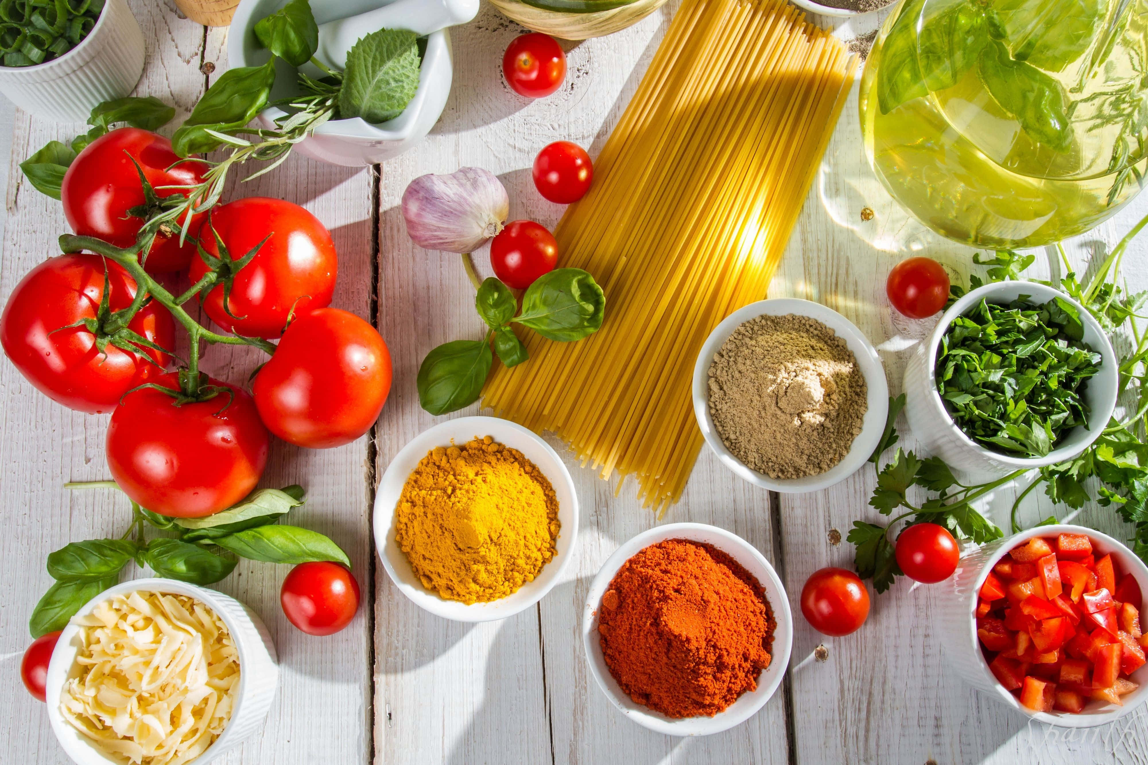 Spices 桌布 壁紙 — 新鮮充滿活力的義大利麵食材，包括番茄、羅勒、大蒜、香料和麵條，排列在質樸的白色木質表面上。