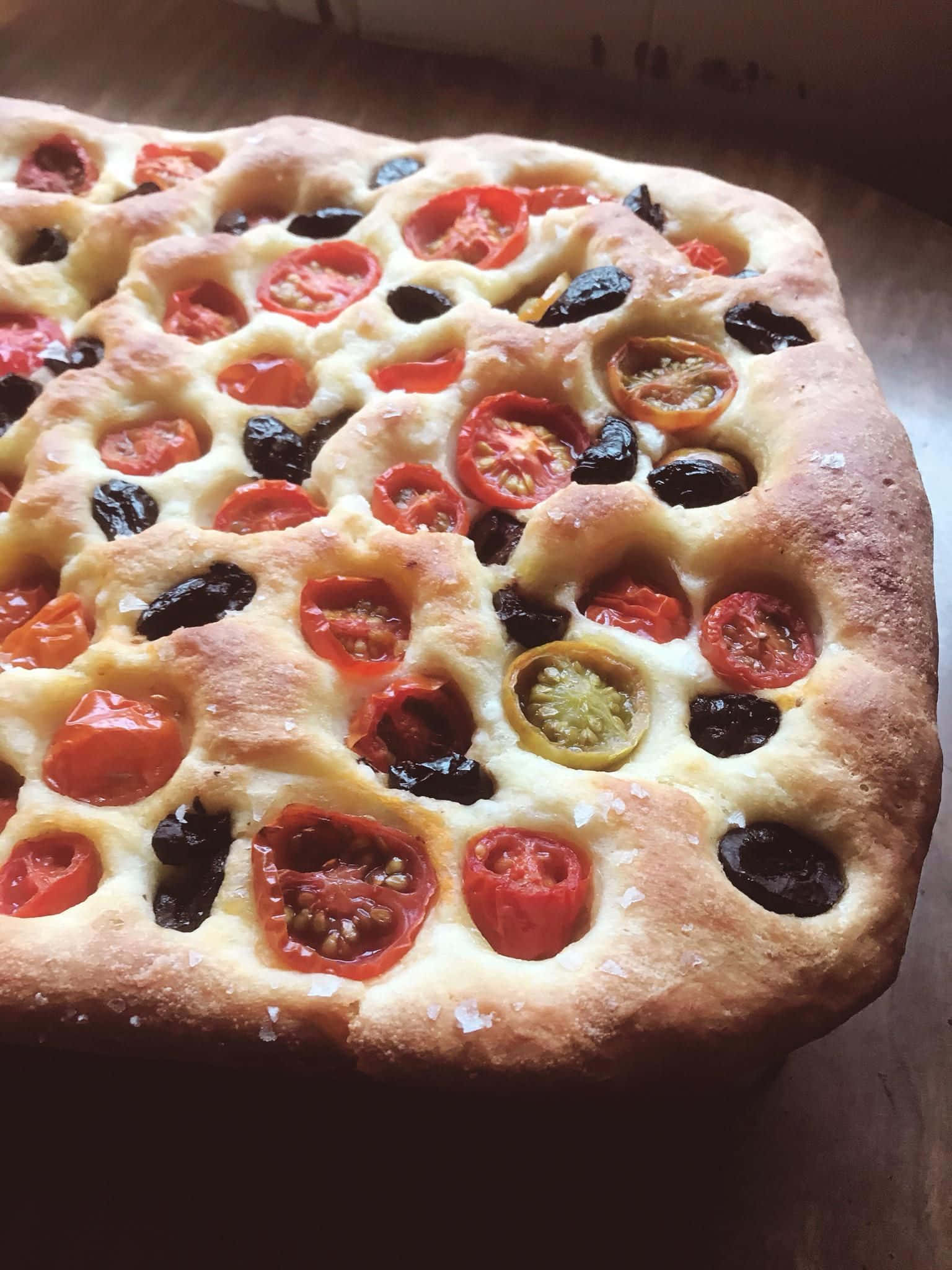 Black Olives 桌布 壁紙 — 新鮮出爐的佛卡夏麵包，上面鋪了半邊小番茄和飽滿的黑橄欖。