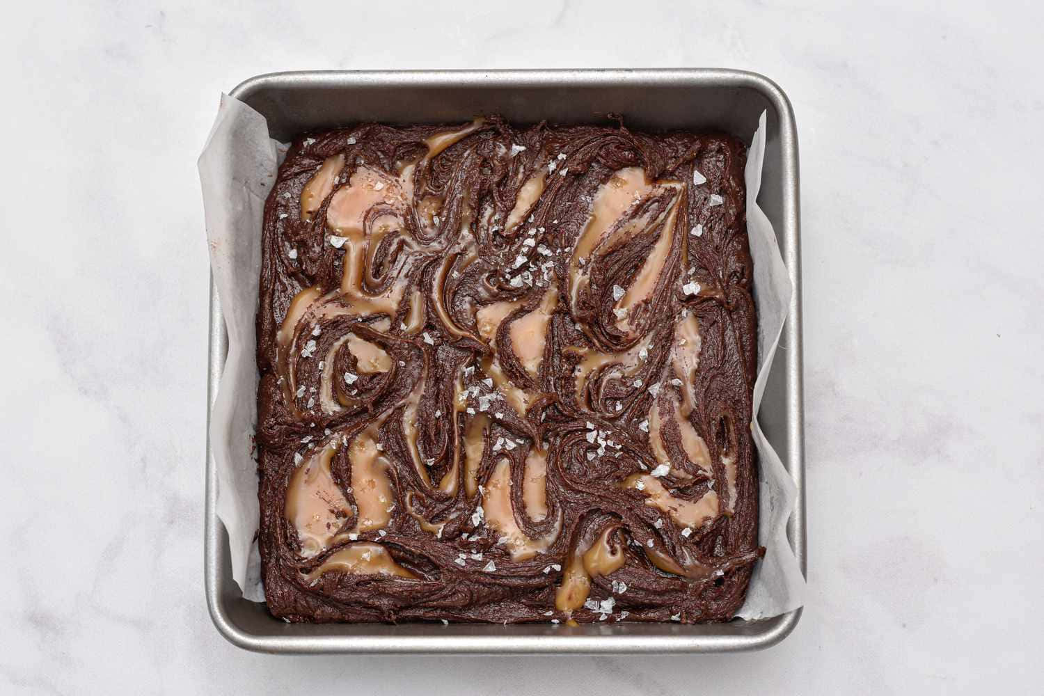 Caramel Brownie 桌布 壁紙 — 新鮮出爐的巧克力花生醬漩渦布朗尼，放在金屬烤盤上，撒上薄片海鹽。