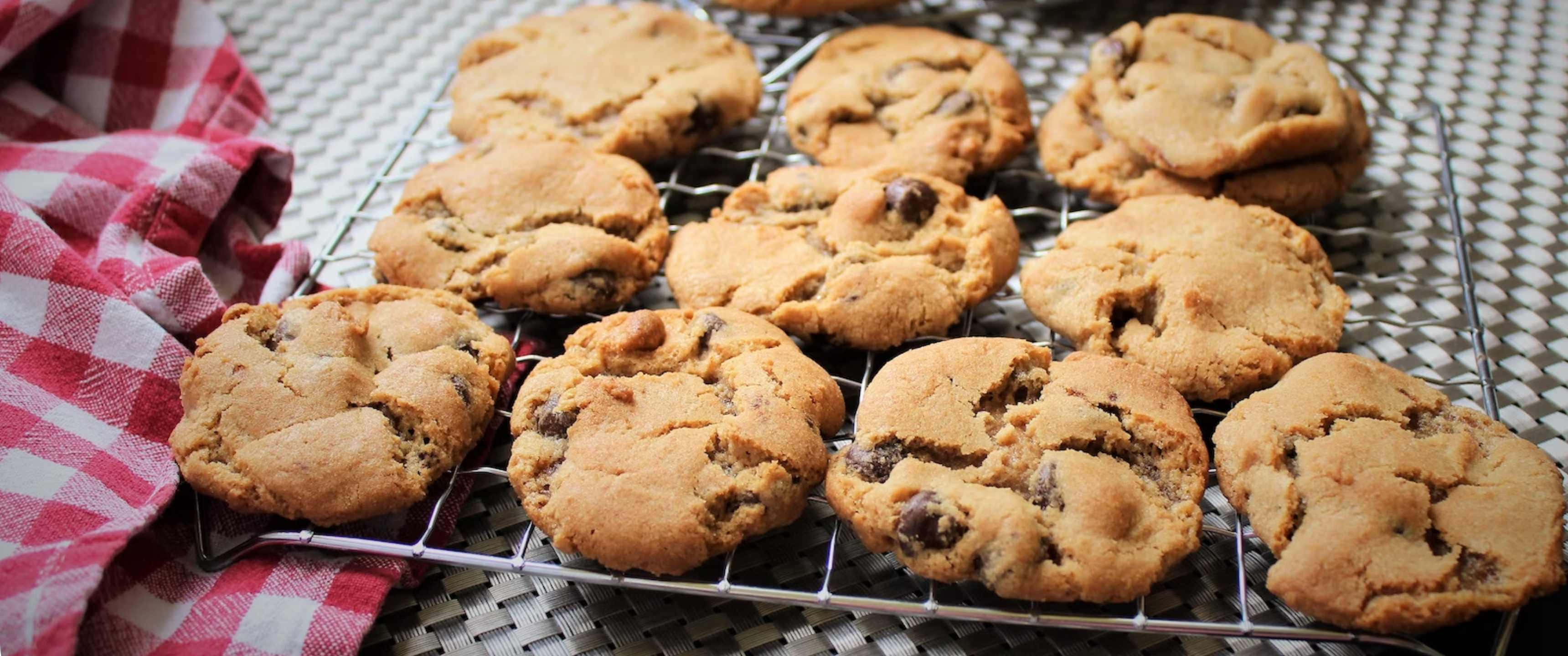 Cookies 桌布 壁紙 — 新鮮出爐的巧克力餅乾在金屬架上冷卻，旁邊放著紅白格子布。