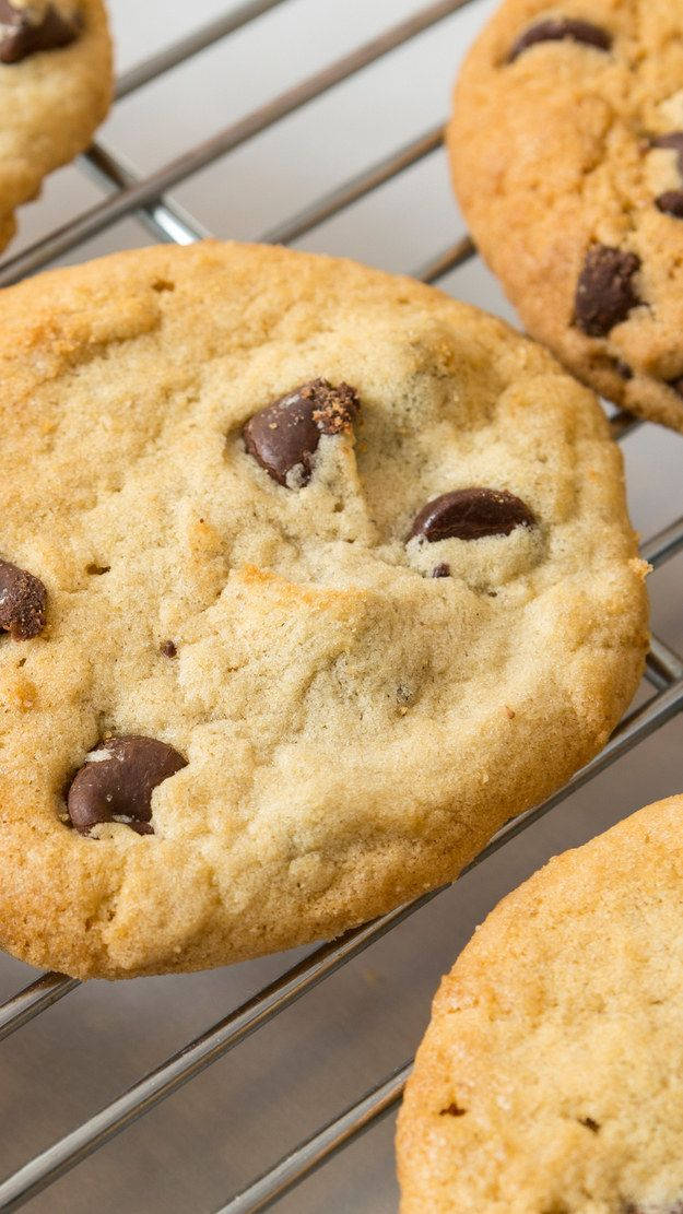 Cookie 桌布 壁紙 — 新鮮出爐的巧克力餅乾在金屬架上冷卻，邊緣金黃，帶有融化的巧克力塊。
