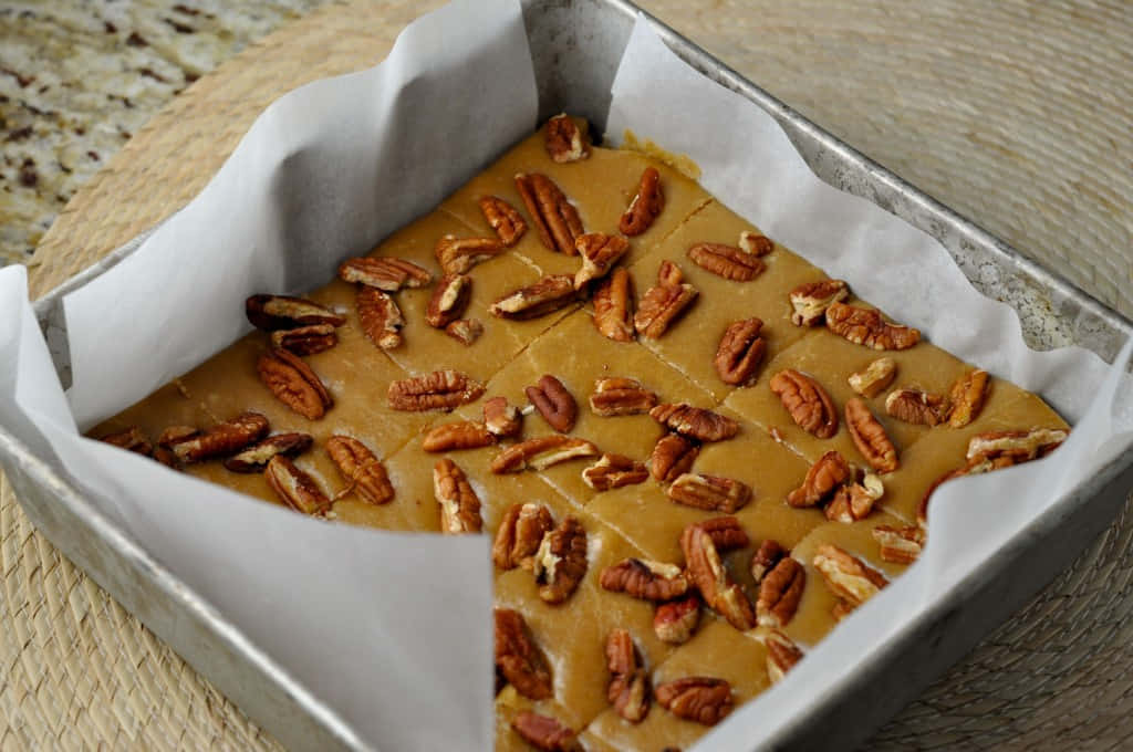 Penuche Fudge 桌布 壁紙 — 新鮮出爐的胡桃派條，放在鋪了烘焙紙的金屬盤上，置於編織墊上。
