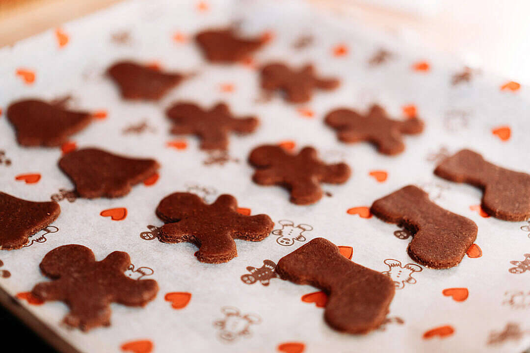 Cookie 桌布 壁紙 — 新鮮出爐的薑餅餅乾，做成男人、襪子和鈴鐺的形狀，放在心形圖案的節日烘焙紙上。
