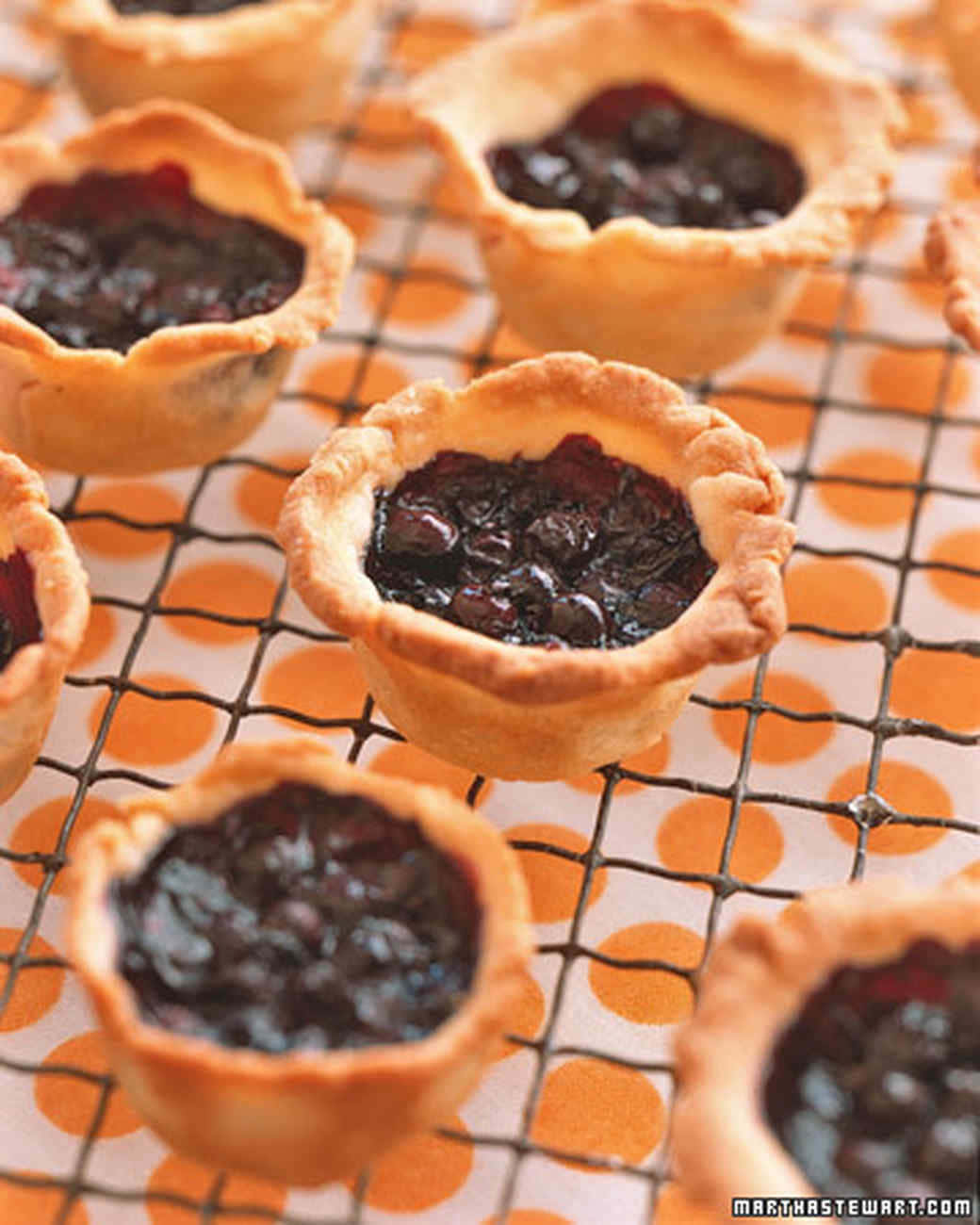 Blueberries Tart 桌布 壁紙 — 新鮮出爐的藍莓塔，金黃色外皮在橙色圓點鐵架上冷卻。