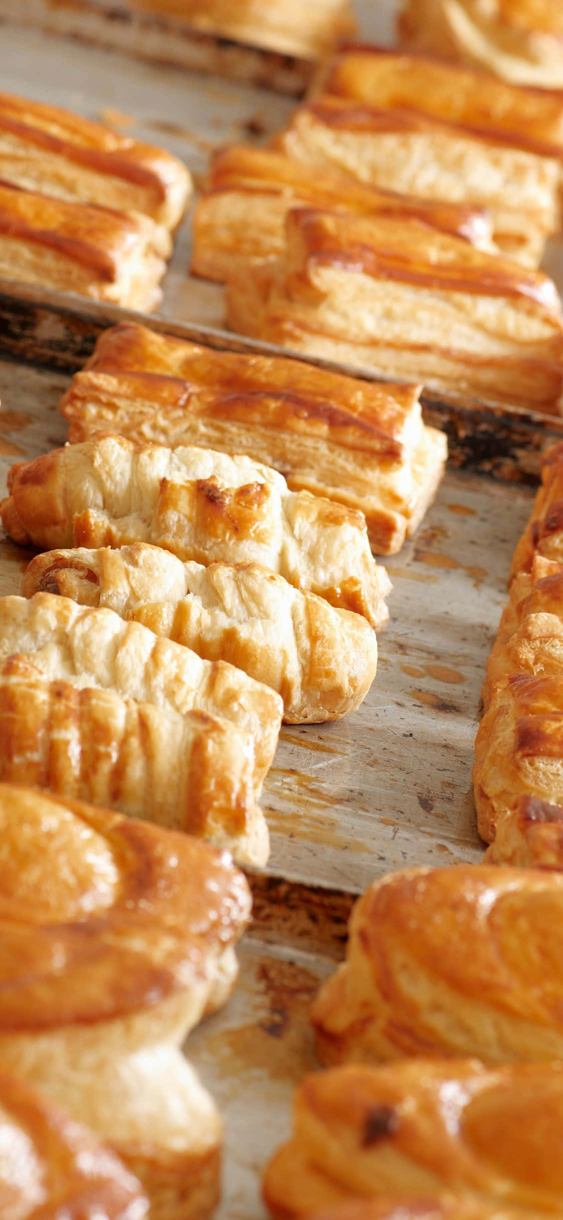 Pastry 桌布 壁紙 — 新鮮出爐的金色酥皮糕點，層層酥脆，放在質樸的烤盤上。