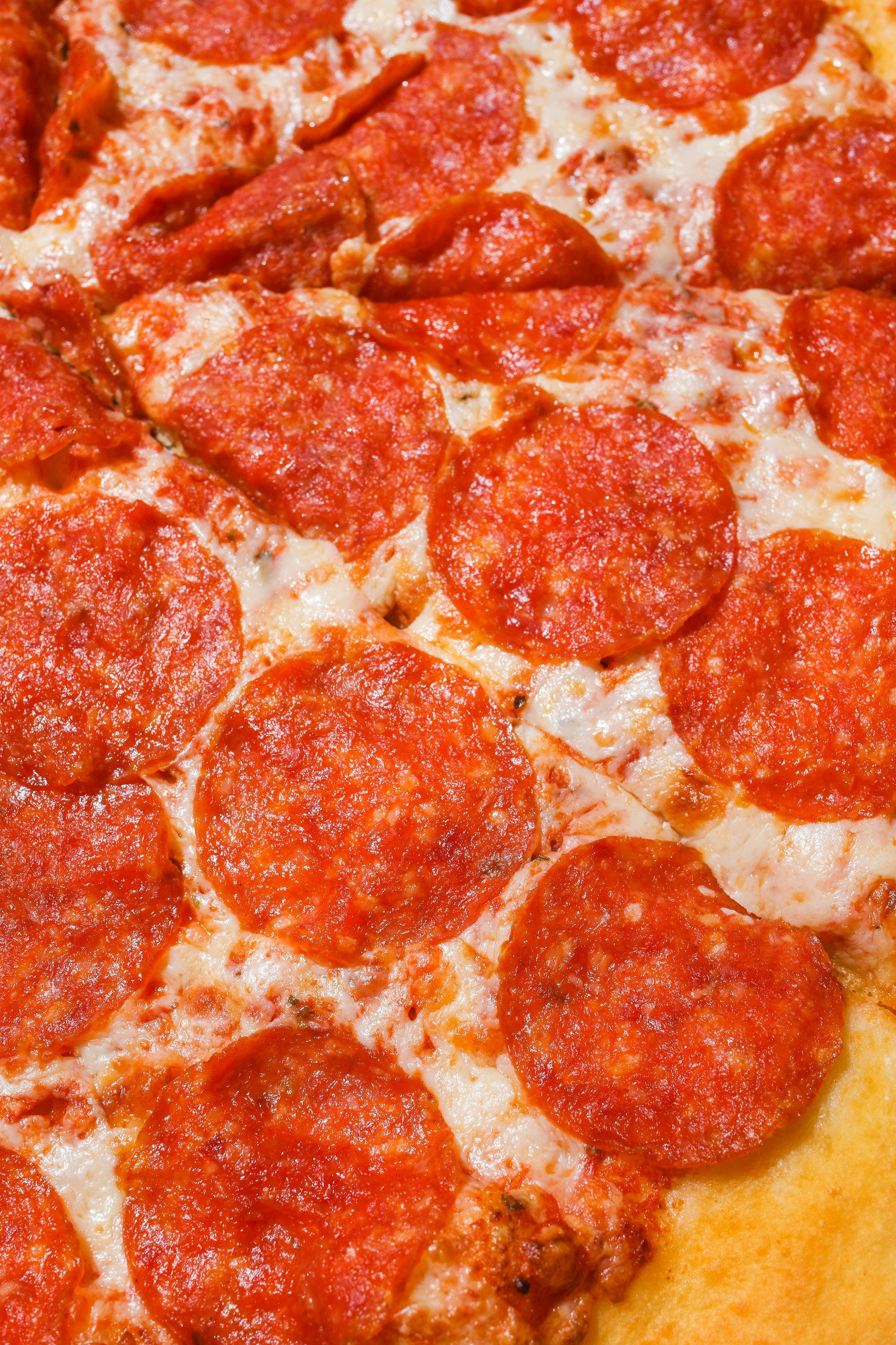 Dominos Pizza 桌布 壁紙 — 新鮮出爐義大利辣肉腸披薩的特寫，有融化的起司和酥脆的配料。