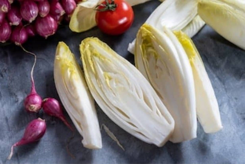 Food Photography 桌布 壁紙 — 新鮮切片菊苣配蘿蔔和番茄，排列在深色紋理表面上。