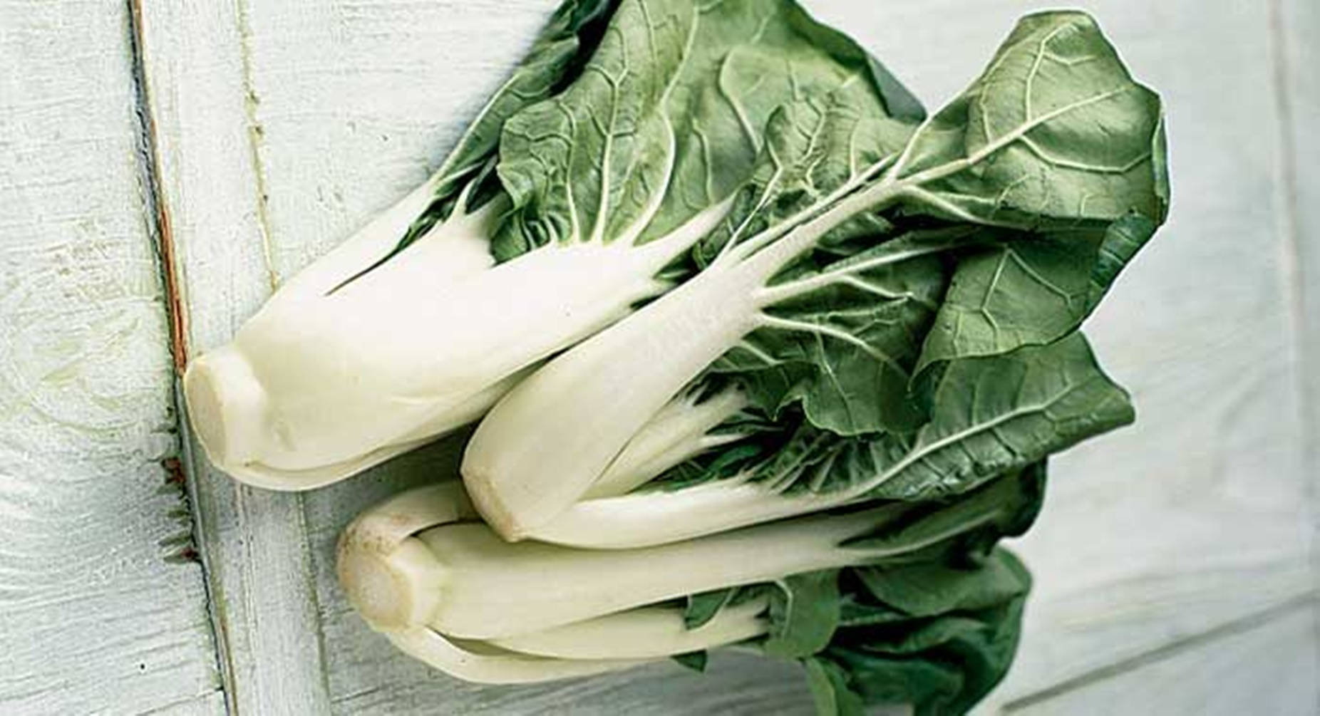 Vegetables 桌布 壁紙 — 新鮮小白菜，莖部潔白爽脆，葉片翠綠鮮活，置於經風化的白色木質表面上。