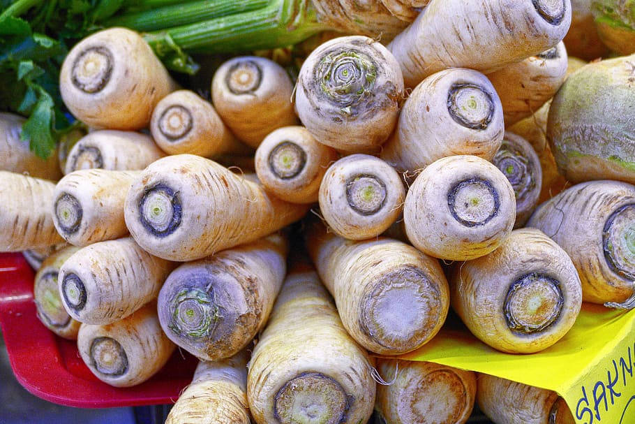 Parsnip 桌布 壁紙 — 新鮮歐洲防風草堆疊高高，帶有綠色頂部和泥土質感的鮮豔特寫。