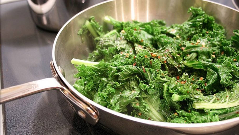 Vegetable 桌布 壁紙 — 新鮮炒好的羽衣甘藍配上紅辣椒片，在不鏽鋼煎鍋中於爐灶上滋滋作響。
