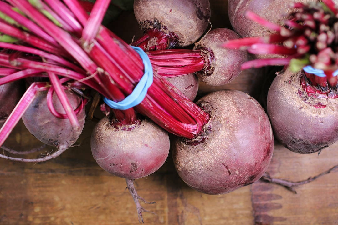 beetroot 桌布 壁紙 — 新鮮甜菜根帶有鮮紅色莖部，用藍色絲帶捆綁，放置在質樸的木質表面上。