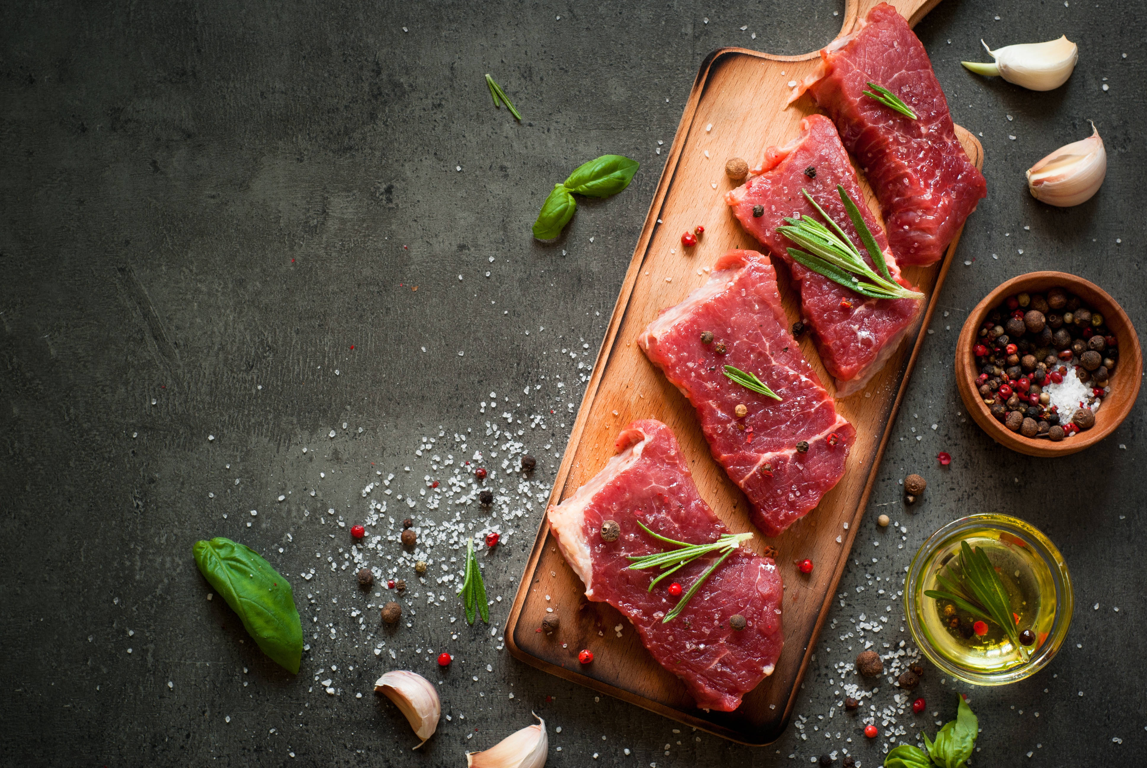meat 桌布 壁紙 — 新鮮生牛肉排，以迷迭香鹽和胡椒粒點綴，放在質樸的木板上。