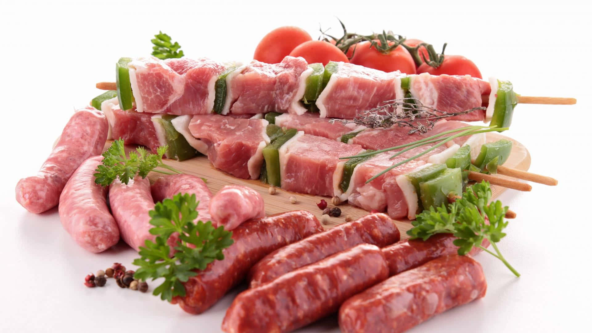 meat 桌布 壁紙 — 新鮮生肉串和香腸，飾以歐芹和櫻桃番茄，放在木板上。