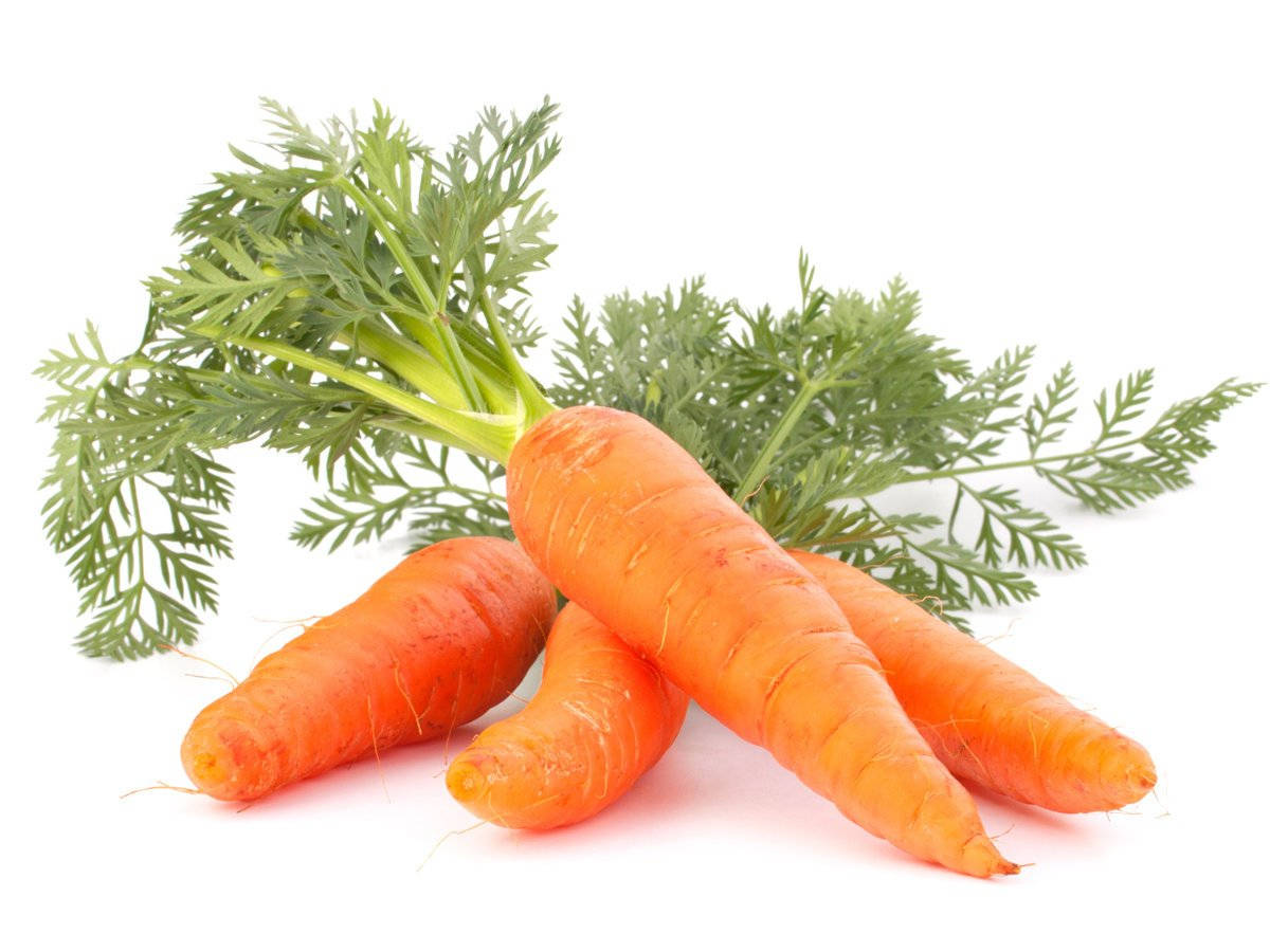 Healthy Food 桌布 壁紙 — 新鮮的橙色胡蘿蔔搭配充滿活力的綠色頂部，排列在潔淨的白色背景上。