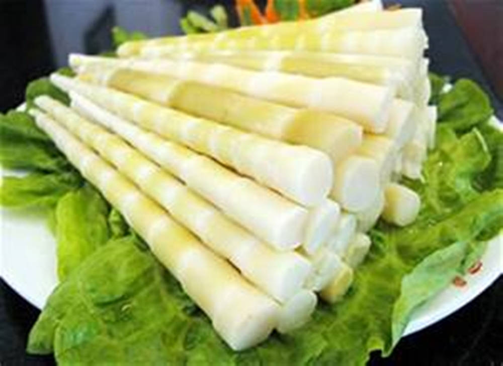 Healthy Food 桌布 壁紙 — 新鮮的淡色竹筍在白色盤子上排列成金字塔形，放在脆綠的生菜葉上。