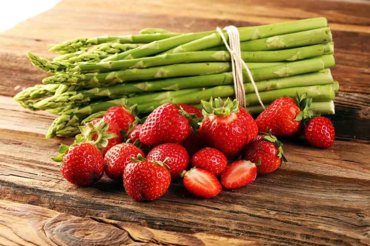 Strawberries 桌布 壁紙 — 新鮮的紅色草莓和綠色蘆筍用麻繩綁在一起，放在質樸的木質表面上。