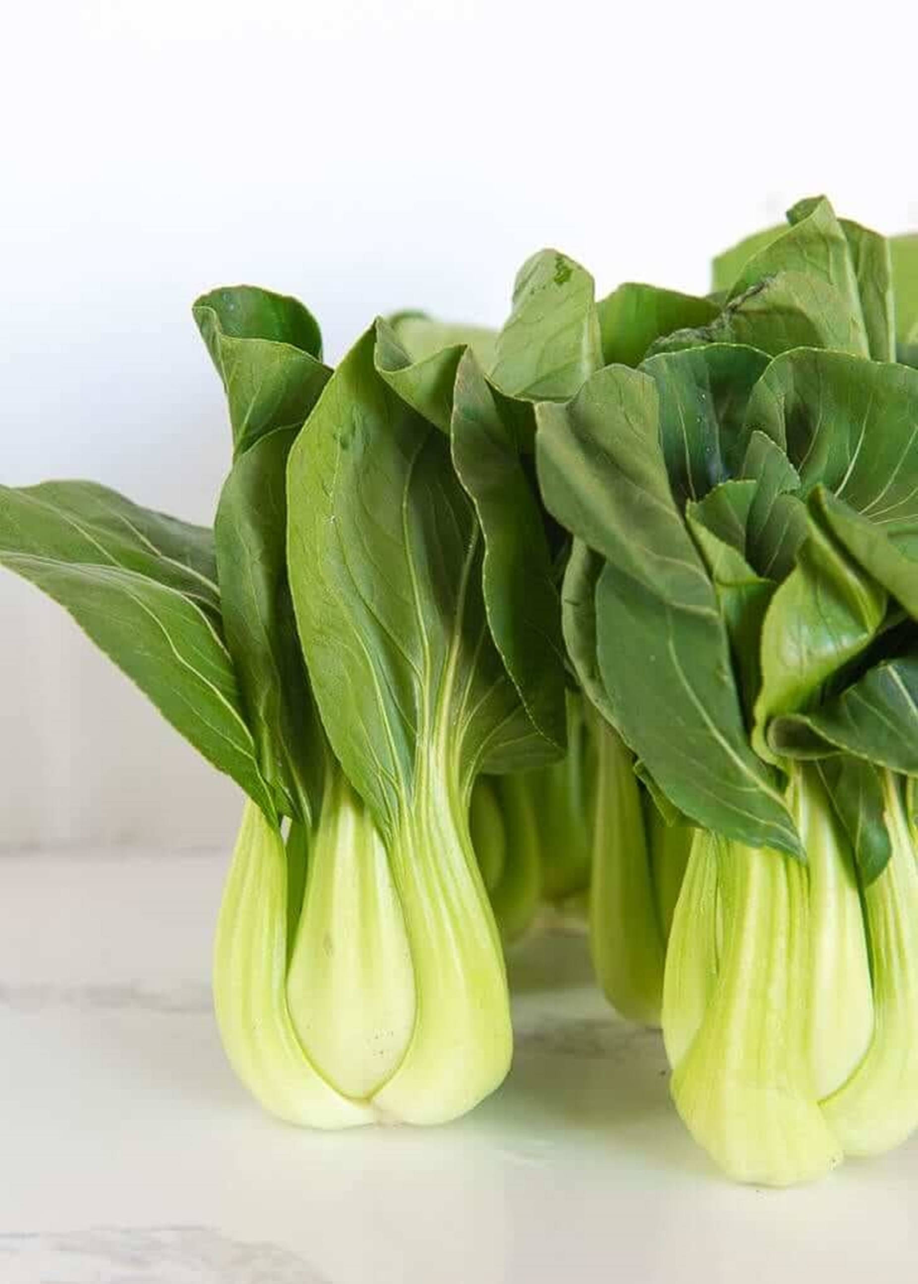 Vegetables 桌布 壁紙 — 新鮮的青江菜，帶有鮮綠色的葉子和淺色的莖，整齊地放在白色大理石表面上。