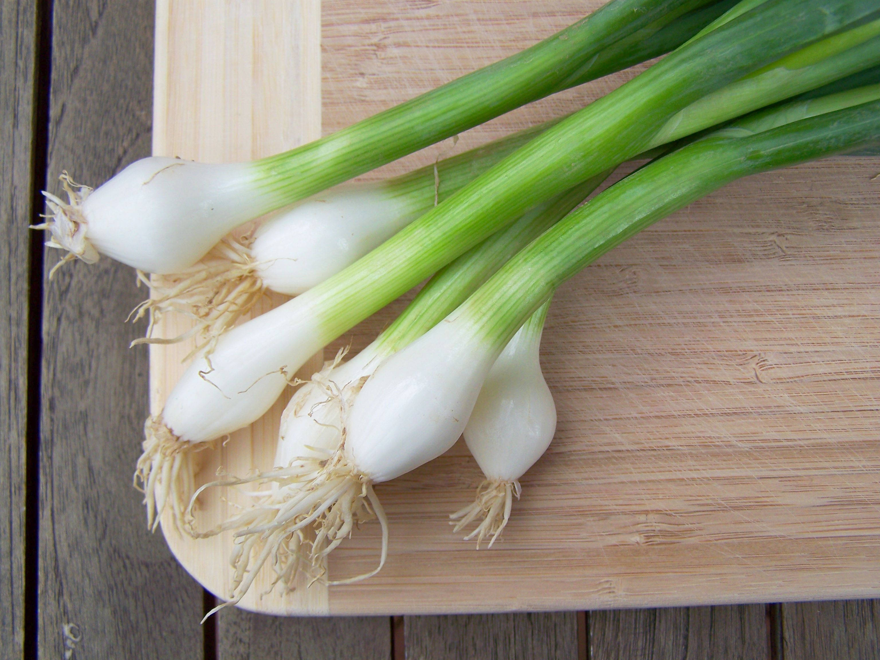 Vegetables 桌布 壁紙 — 新鮮的青蔥，白色蔥頭和綠色蔥葉，放在淺色木砧板上。
