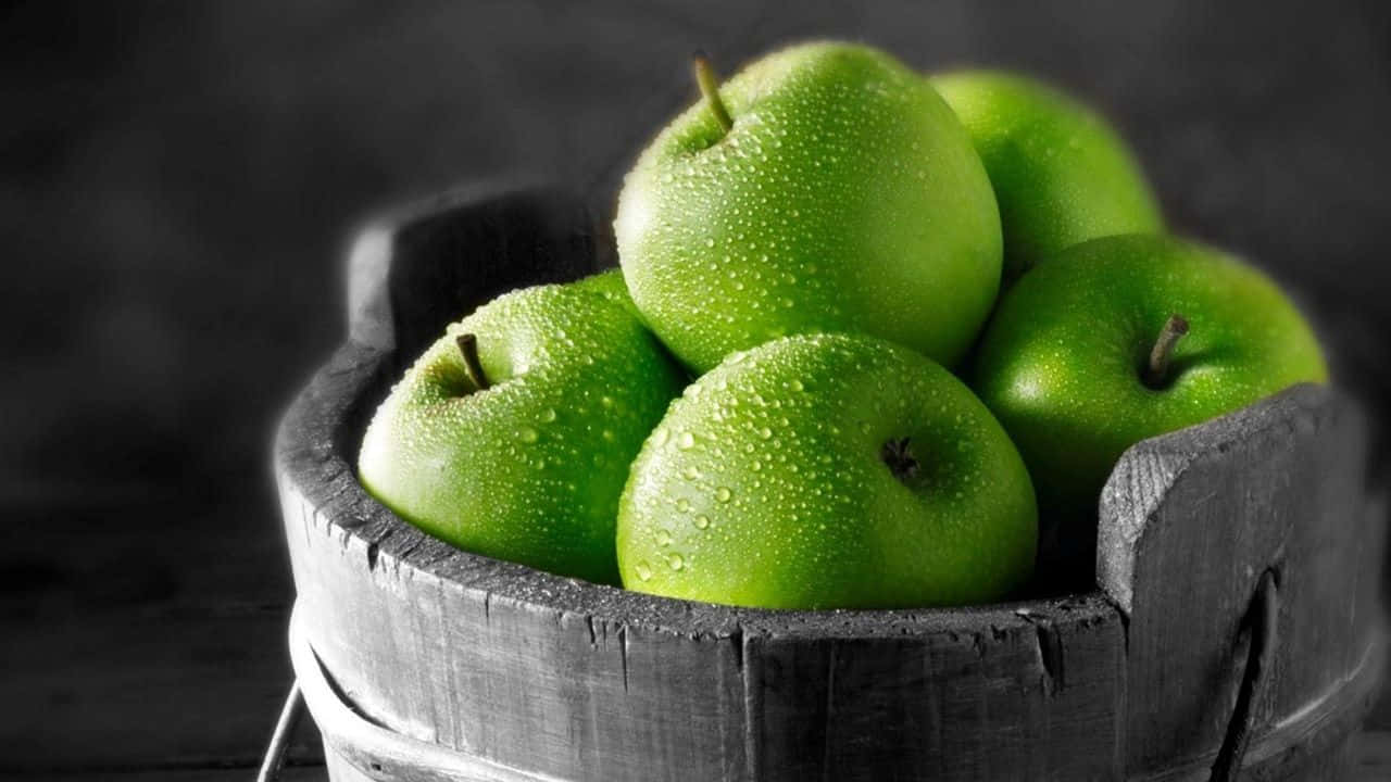 Fruit 桌布 壁紙 — 新鮮的青蘋果閃爍著露珠，依偎在一個質樸的木桶中，背景是陰暗的氛圍。