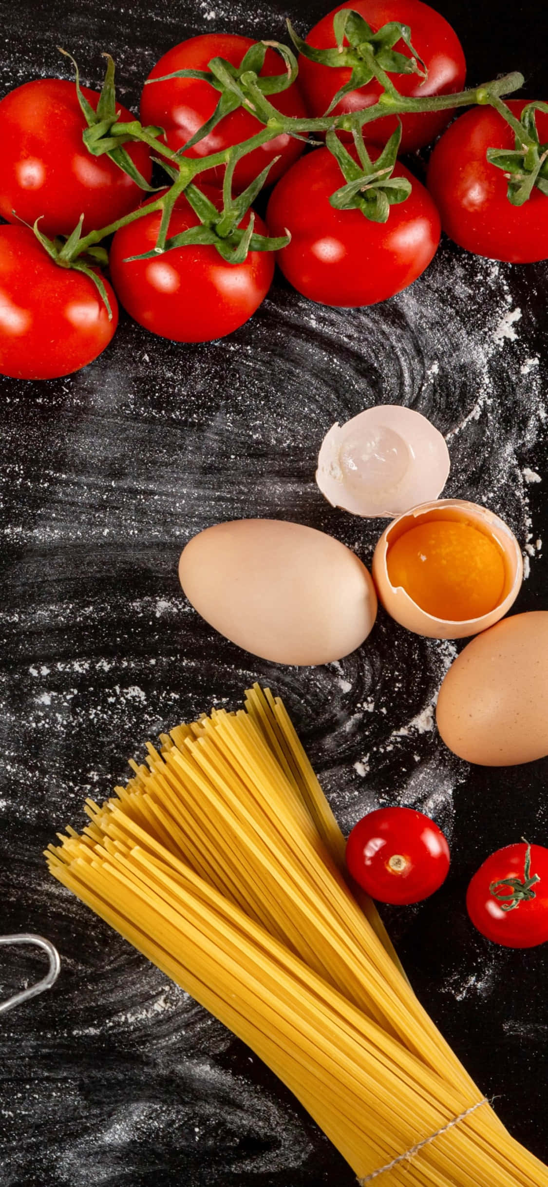 iPhone X Pasta 桌布 壁紙 — 新鮮紅番茄和裂開的雞蛋圍繞著一束未煮熟的義大利麵，放在撒有麵粉的深色表面上。