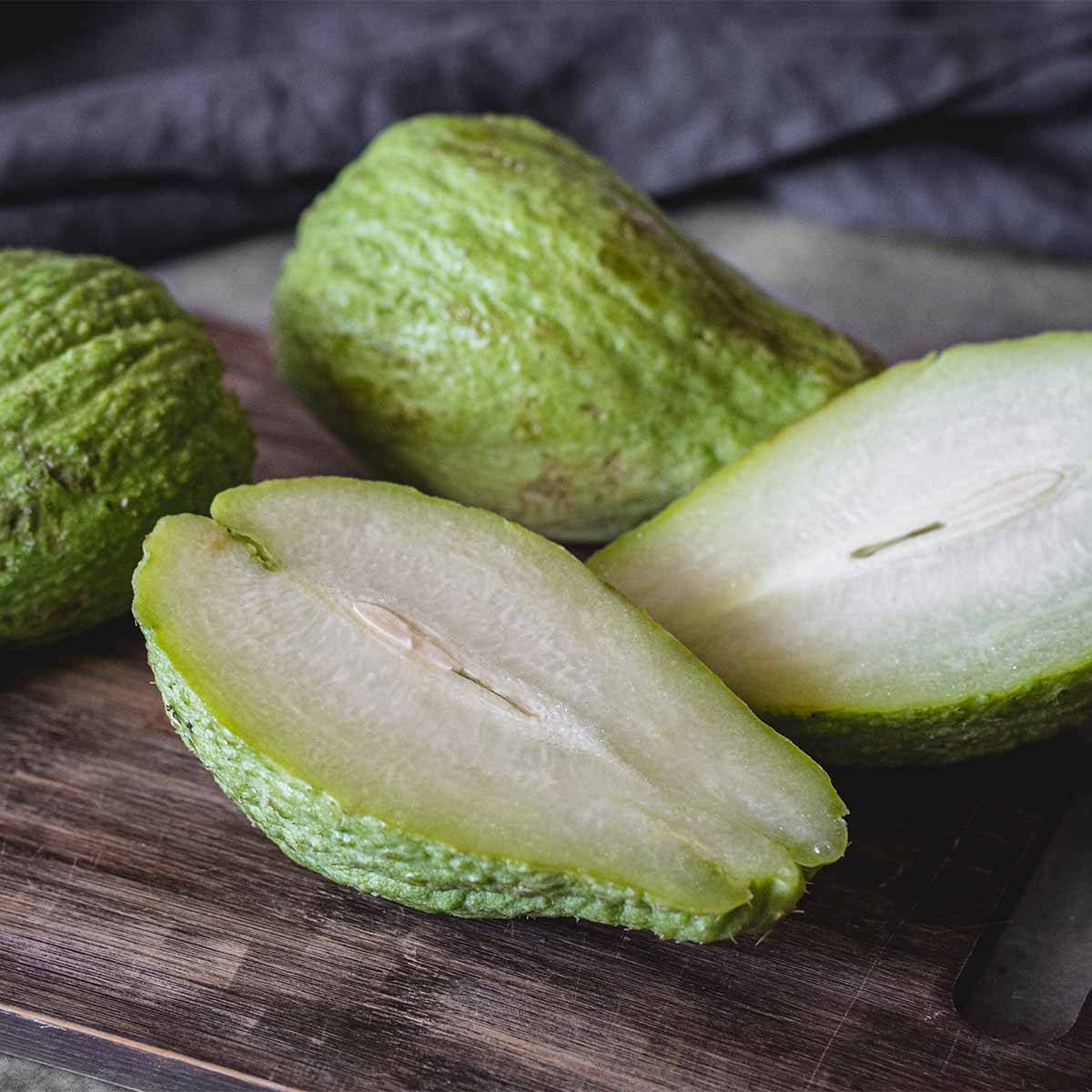 Healthy Food 桌布 壁紙 — 新鮮綠色佛手瓜切開，露出淡色內部，放在質樸木板上。