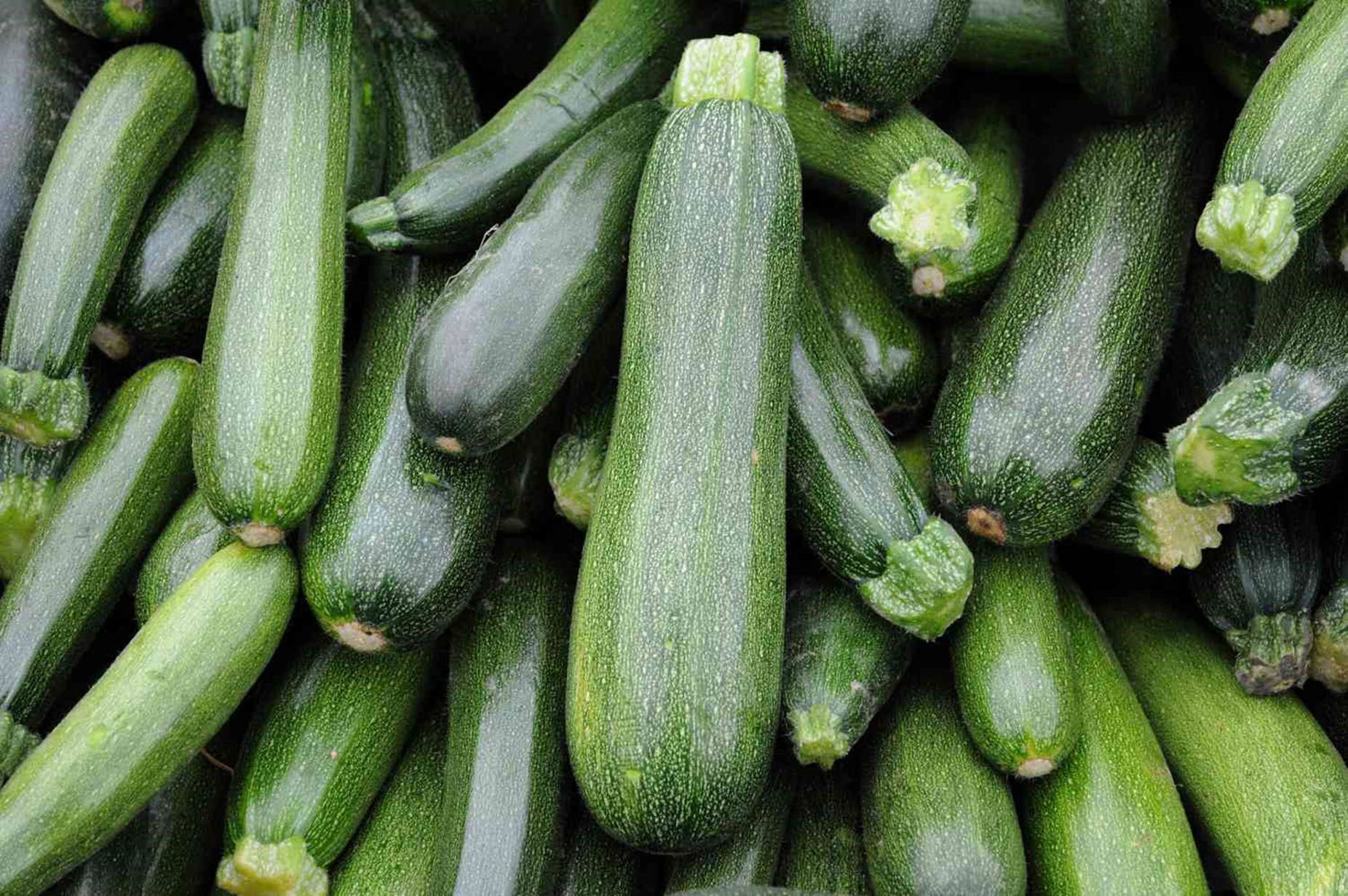 Vegetables 桌布 壁紙 — 新鮮綠色櫛瓜堆疊在一起的特寫，露珠在其帶棱紋的皮上閃閃發光。