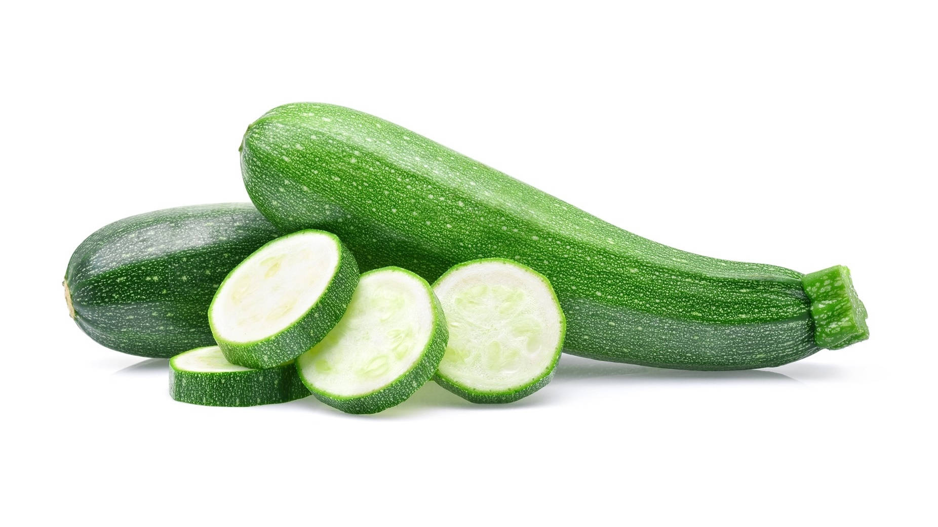 Zucchini 桌布 壁紙 — 新鮮綠色櫛瓜完整及切片，在純白背景上露出淡色內部。