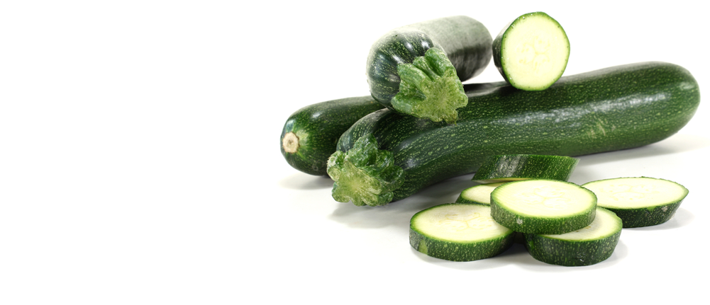 Zucchini 桌布 壁紙 — 新鮮綠色櫛瓜完整及切片，置於潔白表面，帶柔和陰影。
