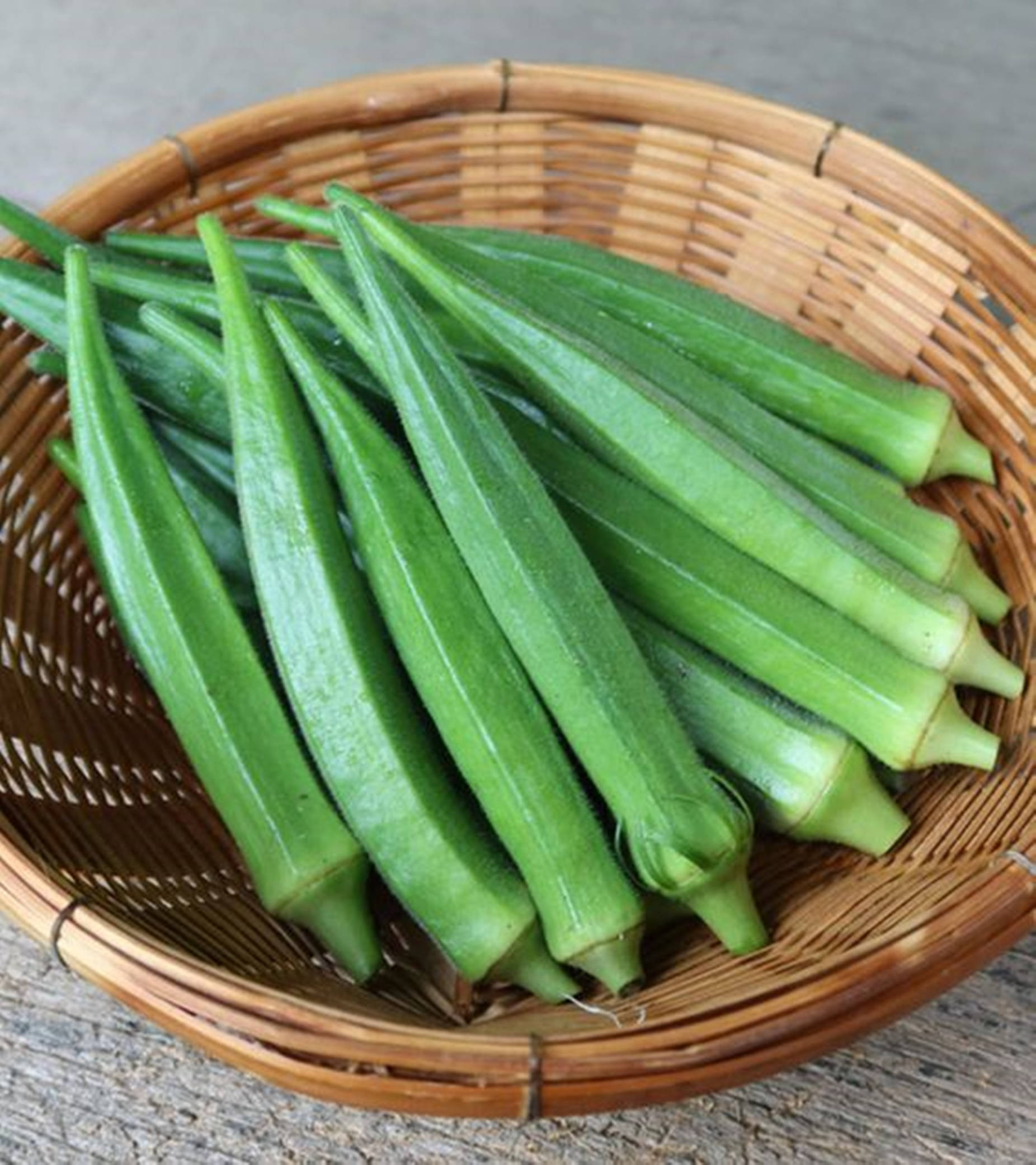 healthy 桌布 壁紙 — 新鮮綠色秋葵莢放在編織竹籃中，置於風化木質表面上。