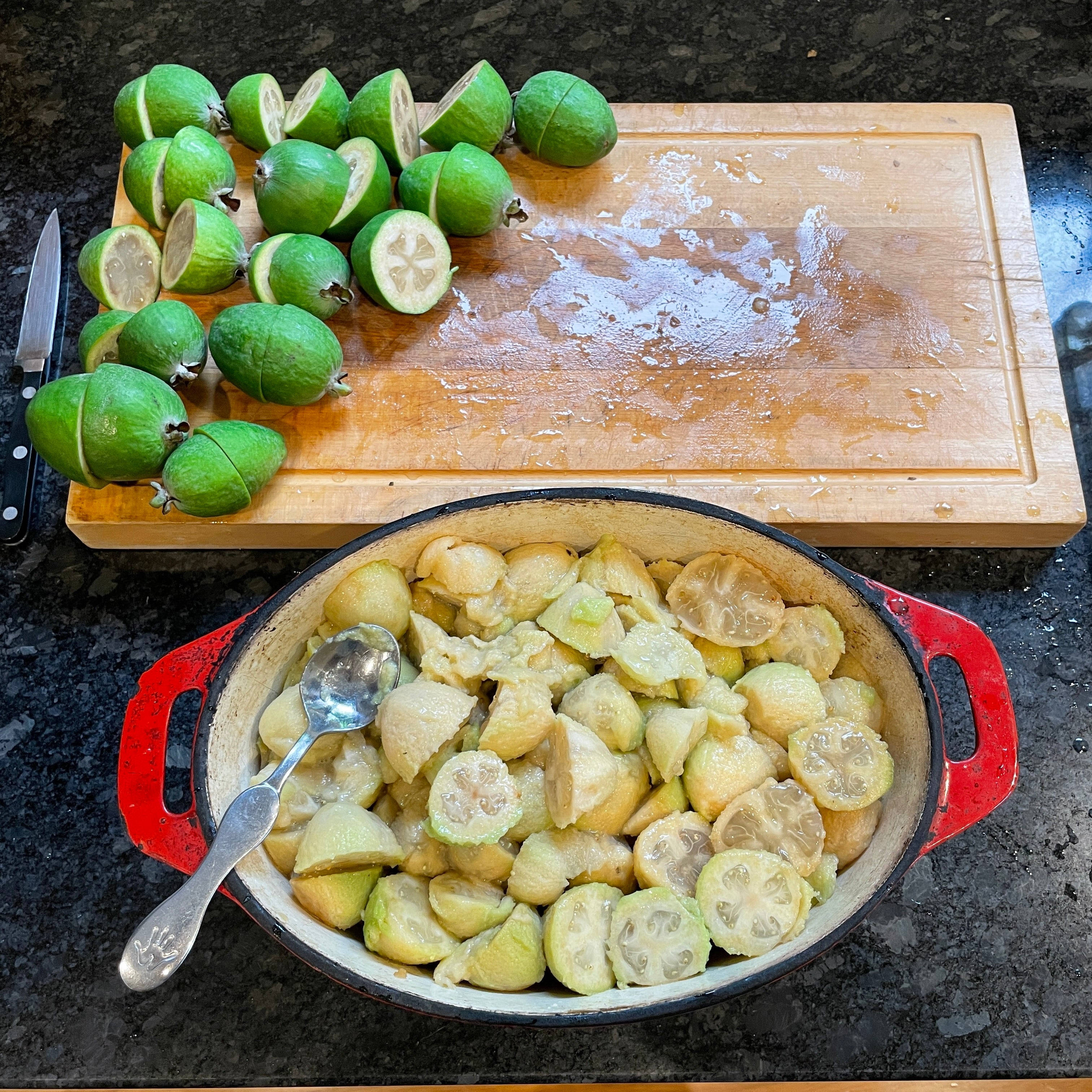 Fruit 桌布 壁紙 — 新鮮綠色菲油果切片後在紅色琺瑯鍋中烹煮，置於深色花崗岩檯面上。