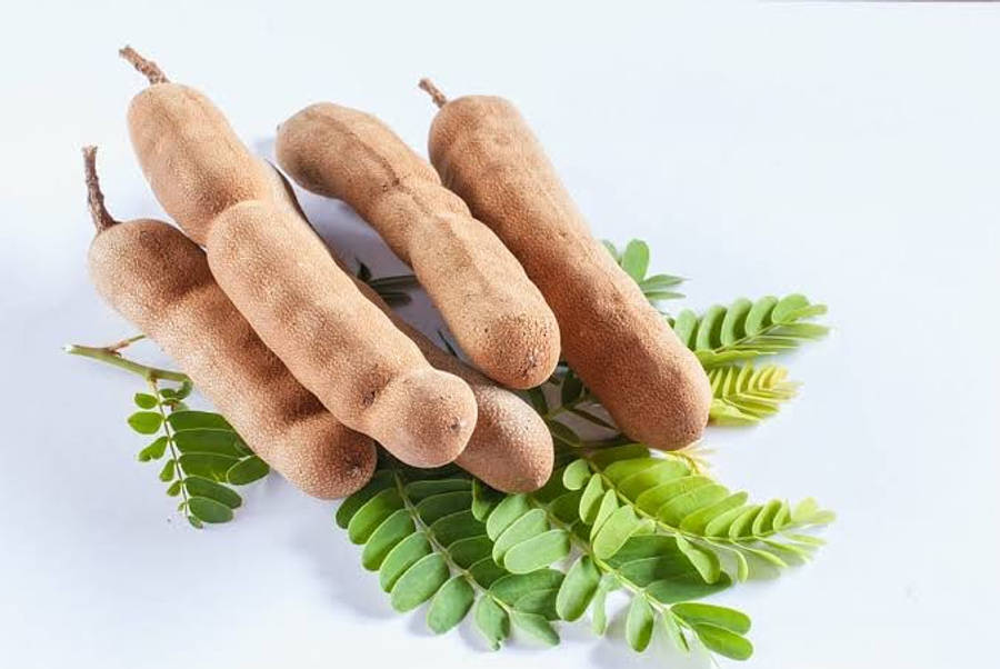 beans 桌布 壁紙 — 新鮮羅望子莢搭配鮮綠色葉子，整齊排列在潔白背景上。