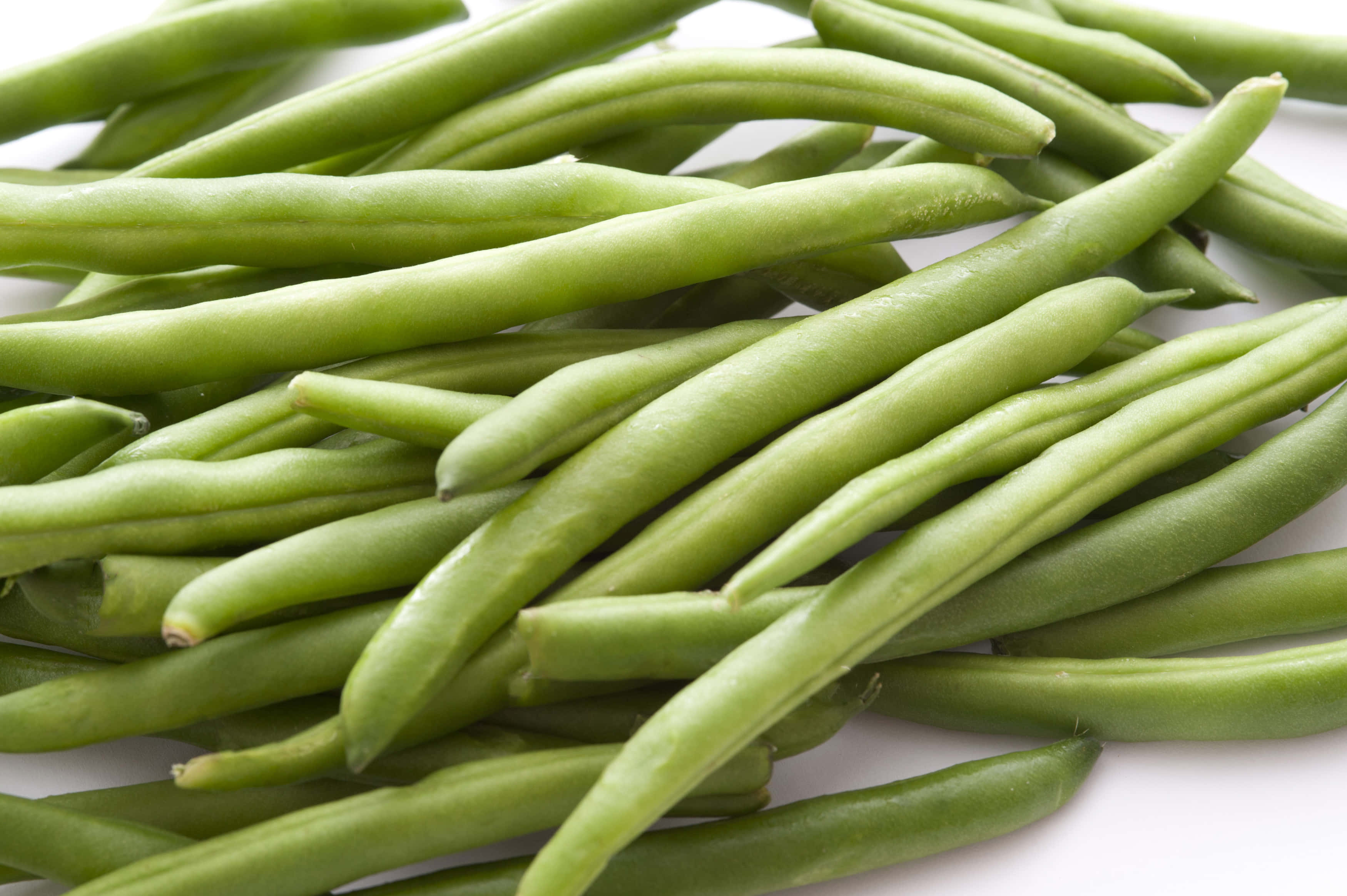 beans 桌布 壁紙 — 新鮮翠綠的豆子堆疊在乾淨白色背景上的特寫照片。