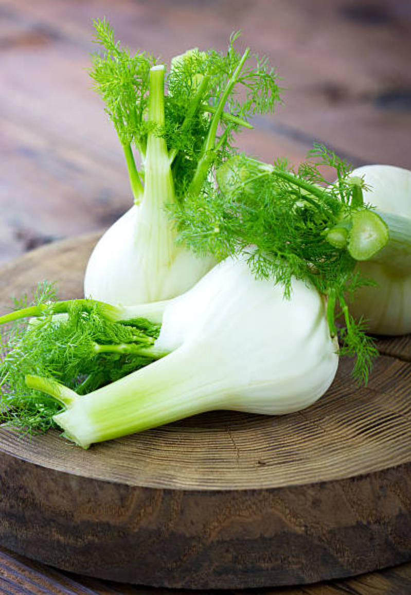 Vegetables 桌布 壁紙 — 新鮮茴香球莖帶有羽毛狀綠色葉子，放在質樸的木砧板上。