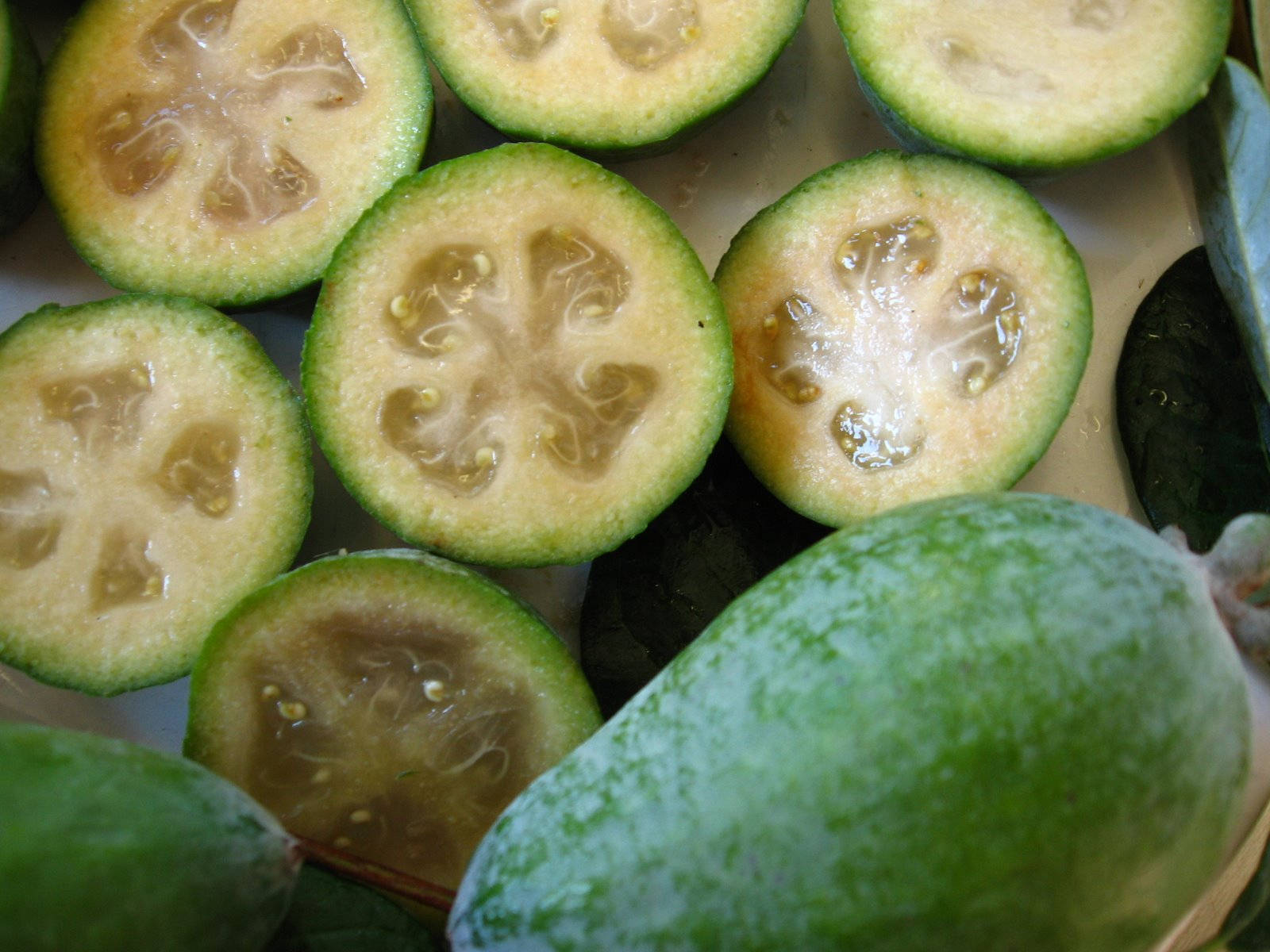 Fruit 桌布 壁紙 — 新鮮菲油果切開，露出星形種子和多汁的淡色果肉，帶綠色果皮。