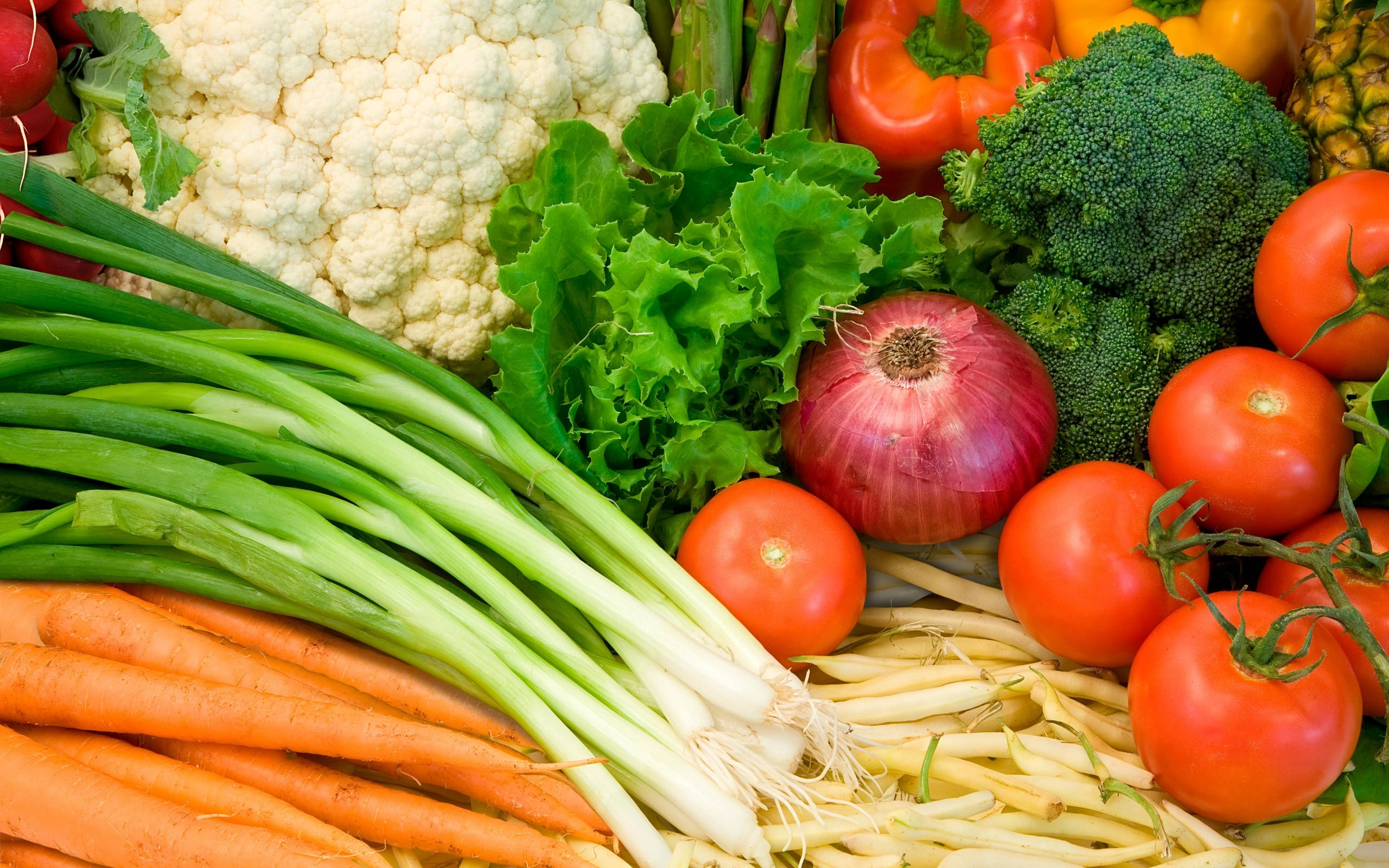 Vegetable 桌布 壁紙 — 新鮮蔬菜的鮮豔特寫，包括胡蘿蔔、洋蔥、番茄、西蘭花和花椰菜，排列成色彩繽紛、豐盛的一堆。
