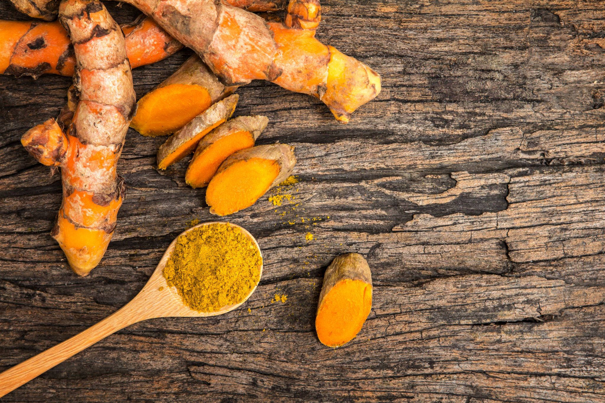 Spices 桌布 壁紙 — 新鮮薑黃根和鮮黃色粉末放在經風化的木質表面上。