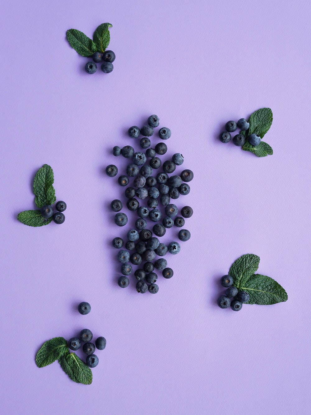 Blueberry 桌布 壁紙 — 新鮮藍莓和薄荷葉在柔軟的薰衣草背景上以散落圖案排列。