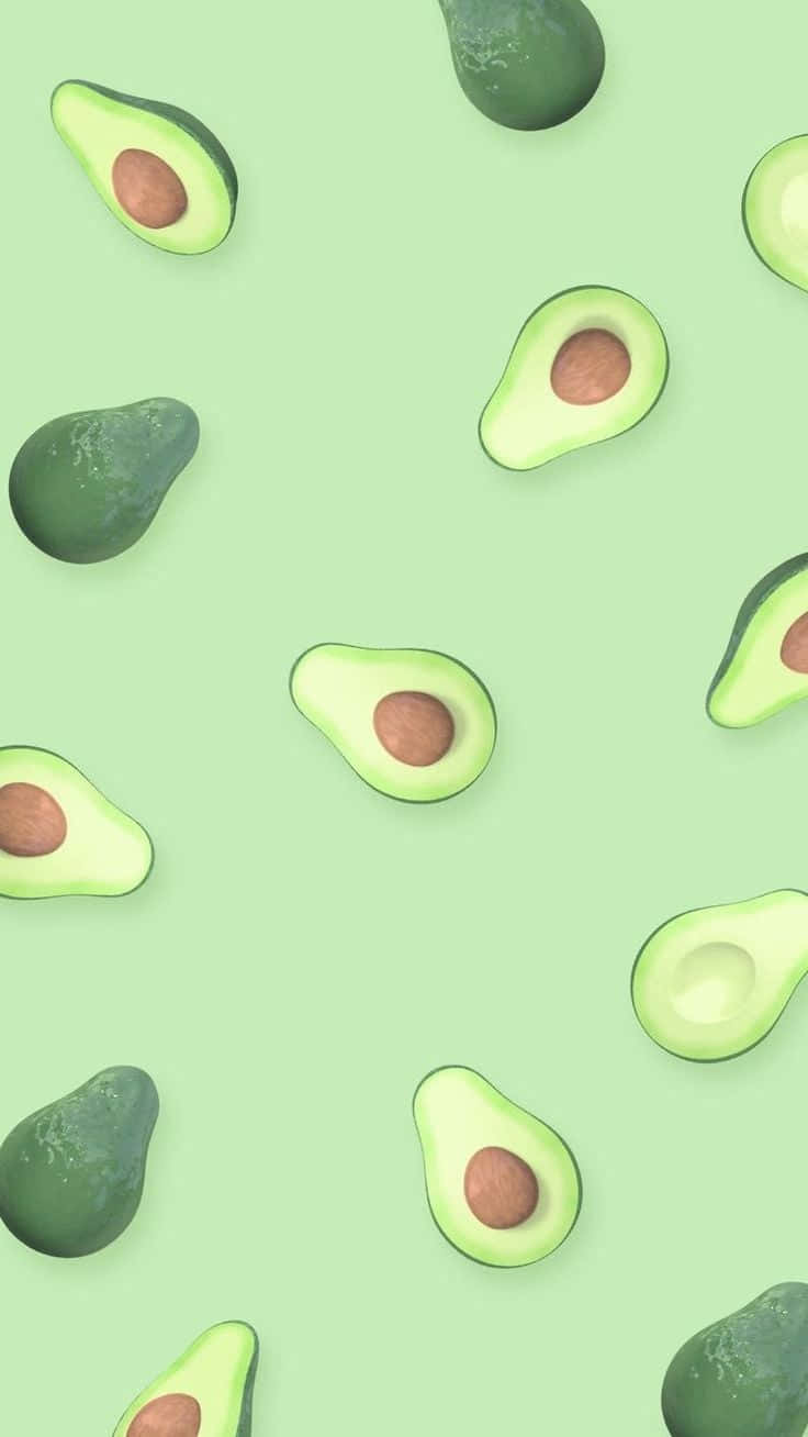 Avocado 桌布 壁紙 — 新鮮酪梨半邊和完整果實散落在柔和的薄荷綠色背景上，形成乾淨的重複圖案。