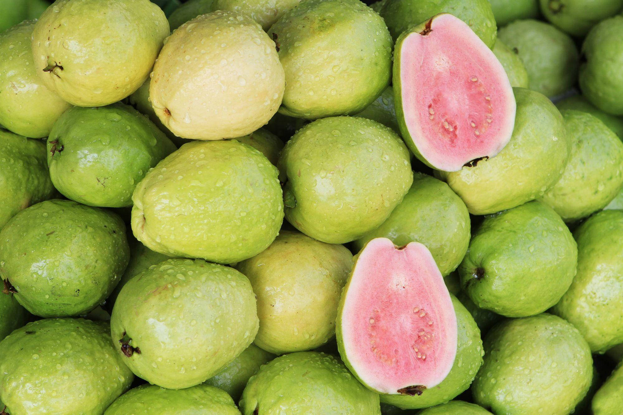 Fruit 桌布 壁紙 — 新鮮青番石榴的特寫，帶有露珠，兩半露出粉紅色果肉。