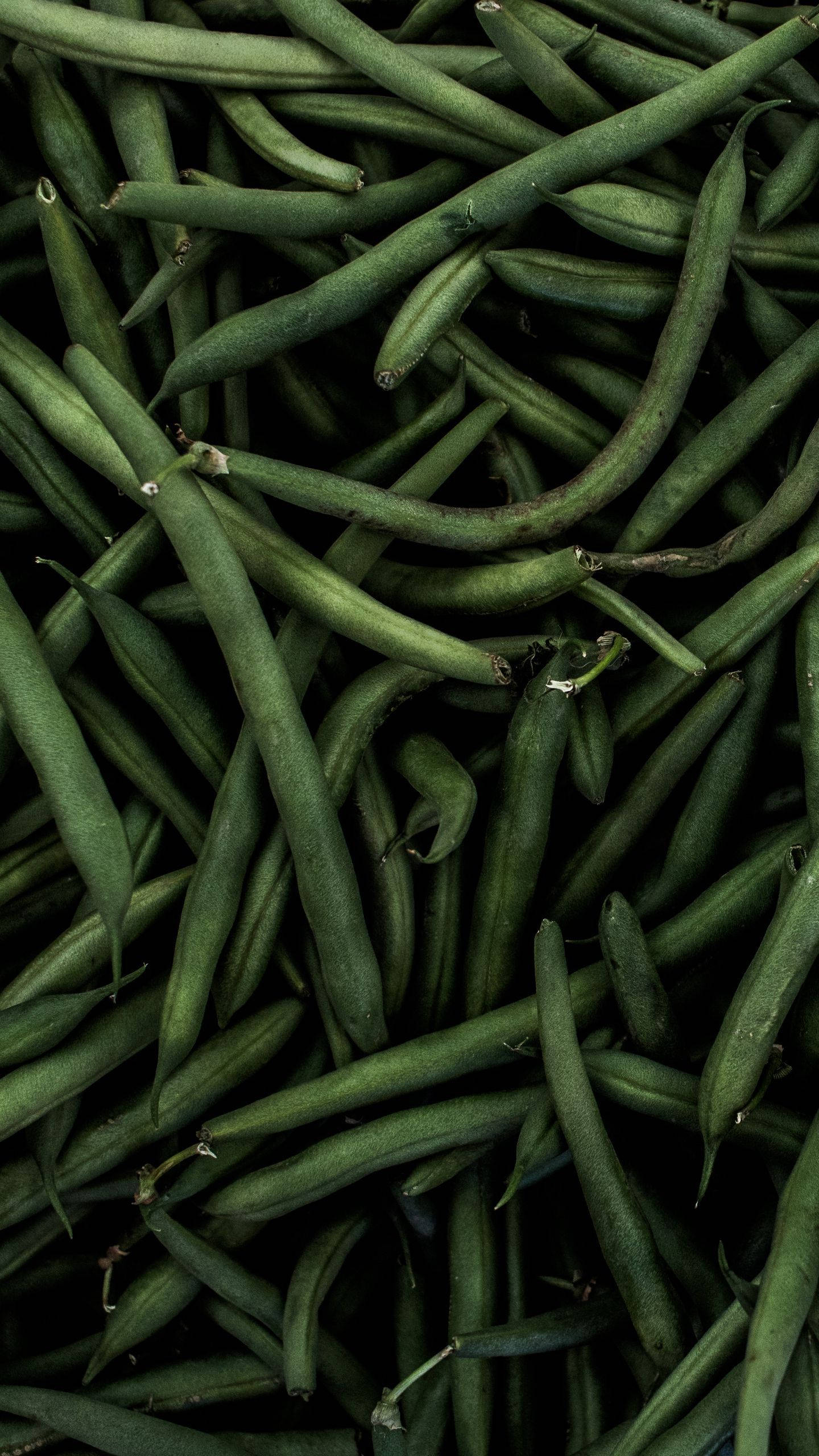 vegan 桌布 壁紙 — 新鮮青豆堆疊在一起的特寫，帶有自然紋理和深邃陰影。