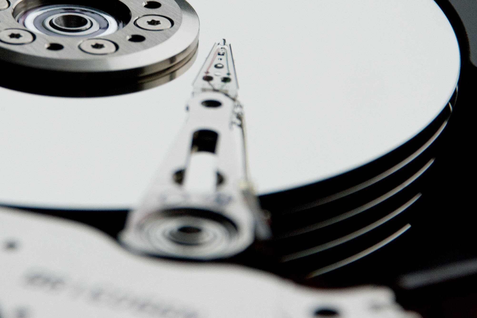 Hard Drive 桌布 壁紙 — 旋轉硬碟碟片的特寫，讀寫頭懸浮在其表面上方。