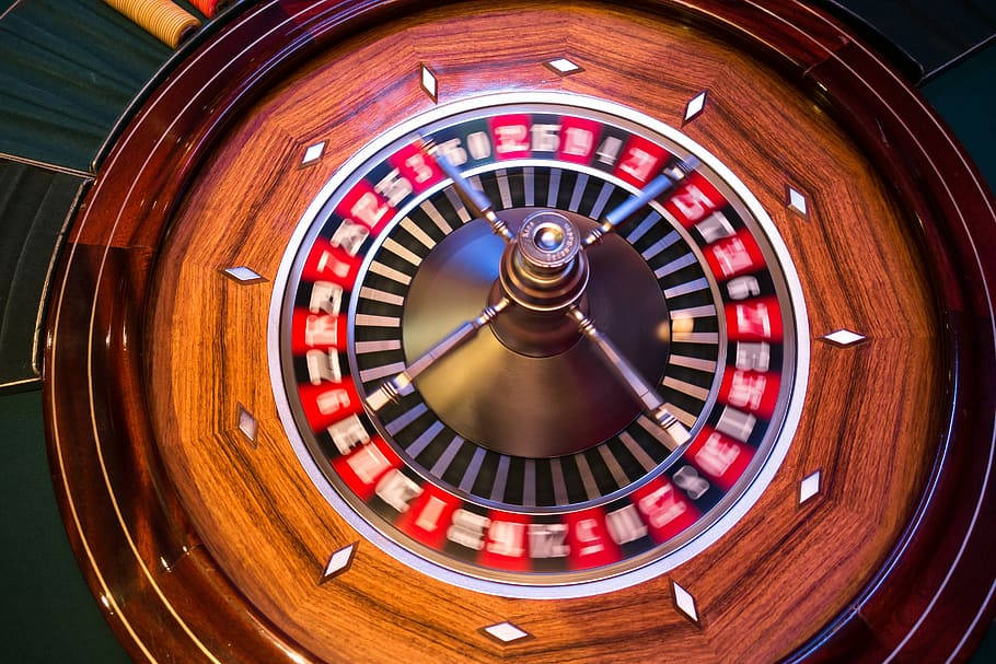 Playing 桌布 壁紙 — 旋轉輪盤的特寫照片，帶有紅色和黑色編號的格子以及拋光木邊。