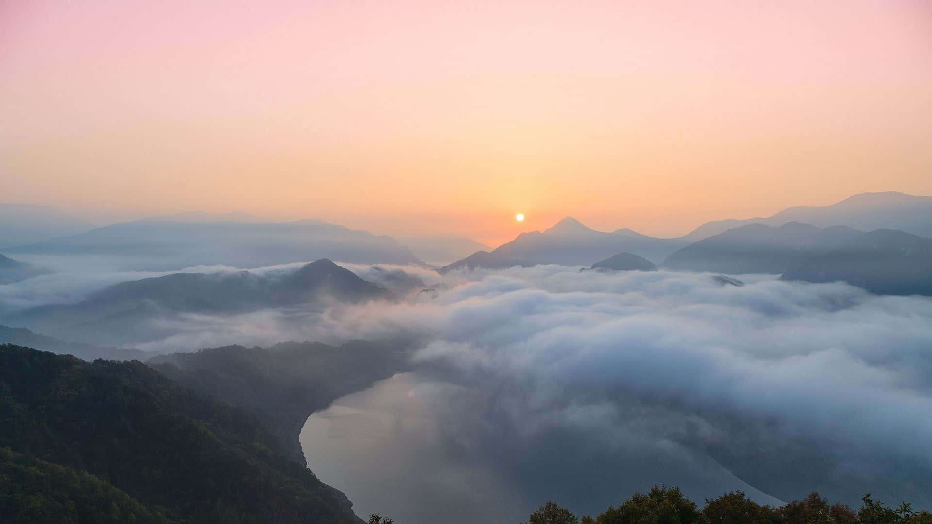 雲朵 桌布 壁紙 — 日出在霧氣繚繞的山脈和蜿蜒河流之間的雲海上繪出粉紅色和橙色的天空。
